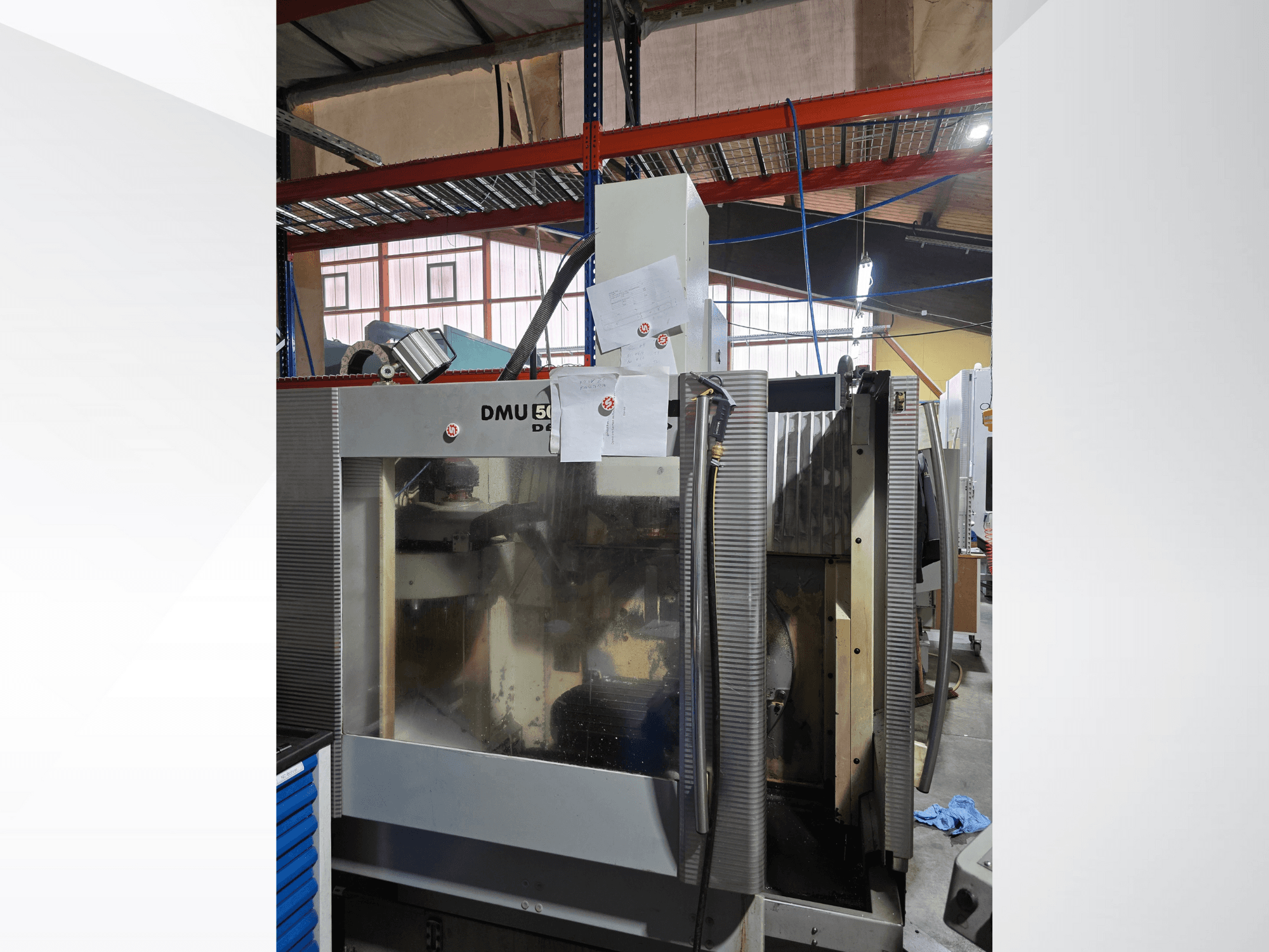 DMU 50 3-akselinen CNC-työstökeskus työpajassa, edestäpäin kuvattuna, ja siinä näkyvät toiminnassa olevat komponentit ja liitetyt asiakirjat.