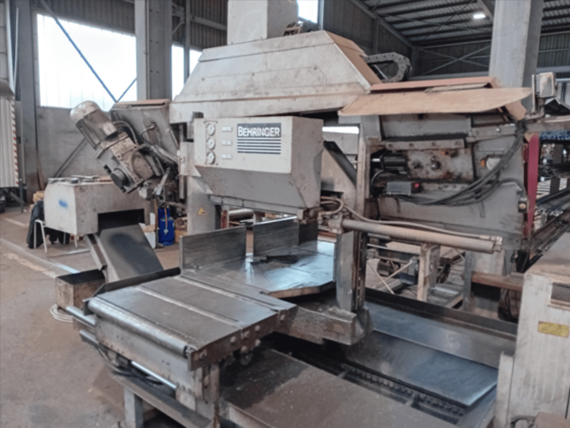 Behringerin vannesaha, etukuva, jossa on suuri terä, moottori ja säädettävä pöytä, ihanteellinen metallin leikkaamiseen työpajassa.