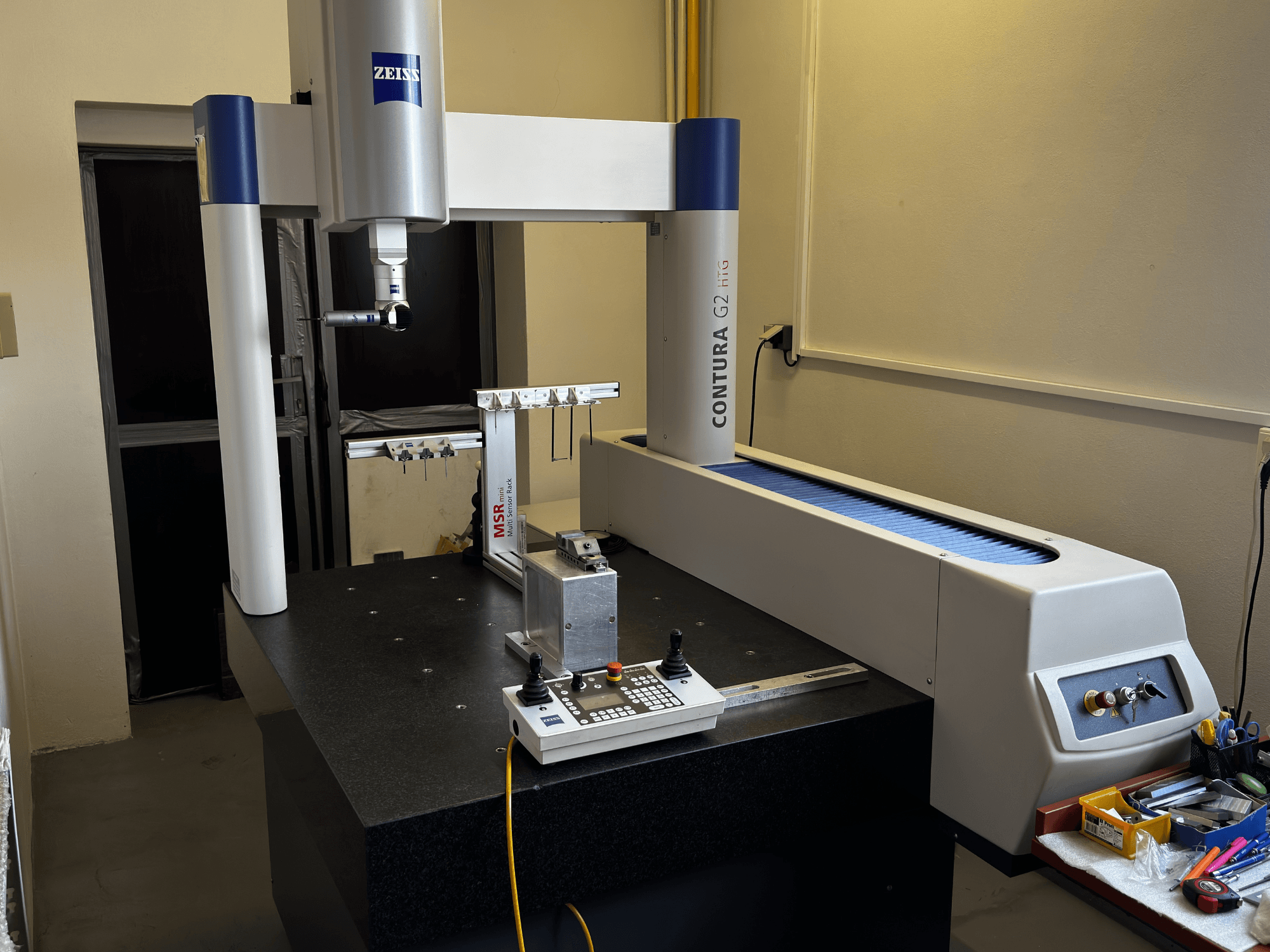 ZEISS Contura G2 CMM laboratorioympäristössä, etukuva, jossa näkyy mittausvarsi, ohjauspaneeli ja viereinen työtila.