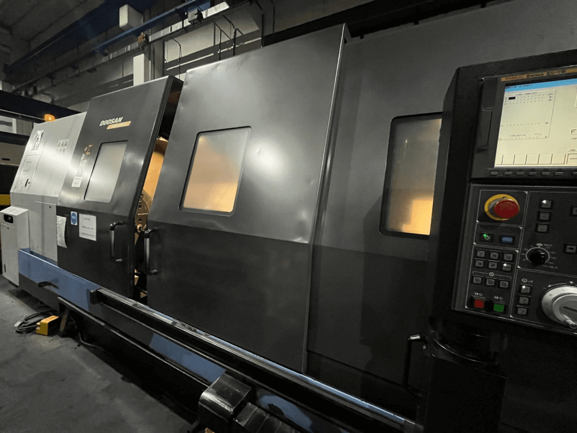 Doosanin CNC-sorvi edestä katsottuna, jossa on ohjauspaneeli ja käyttöliittymä, jossa on näkyvä digitaalinen näyttö ja painikkeet.