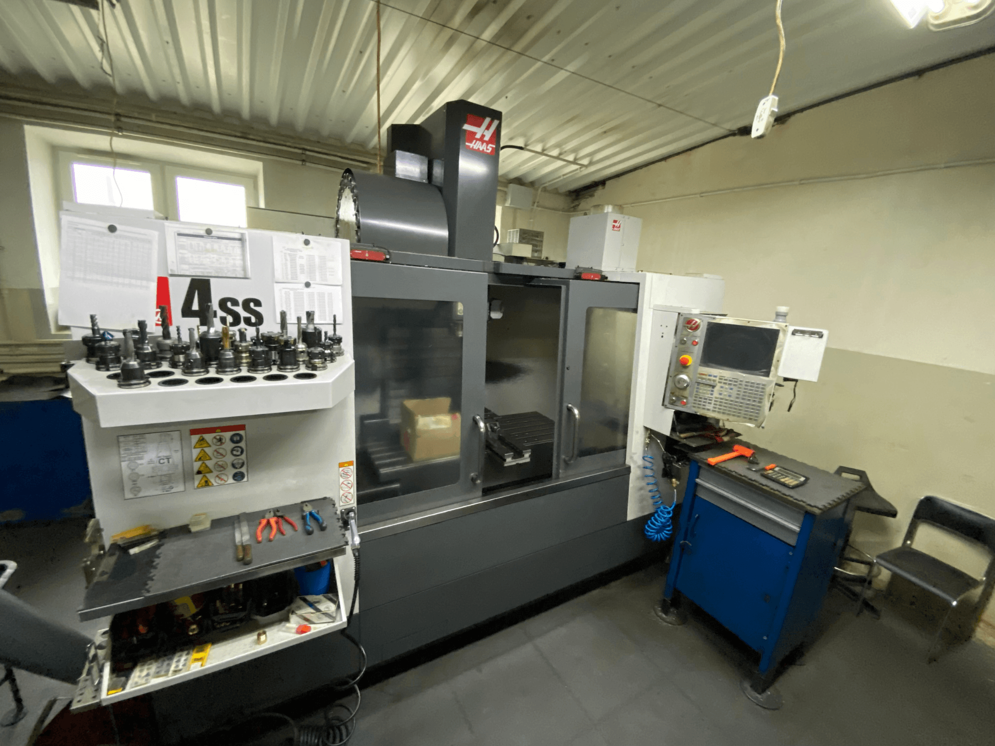 Haas VF-4SS -pystykoneistuskeskus, etunäkymä työkalunpitimineen ja ohjauspaneelineen. Kuvassa näkyvät käytettävät työkalut ja työtila.