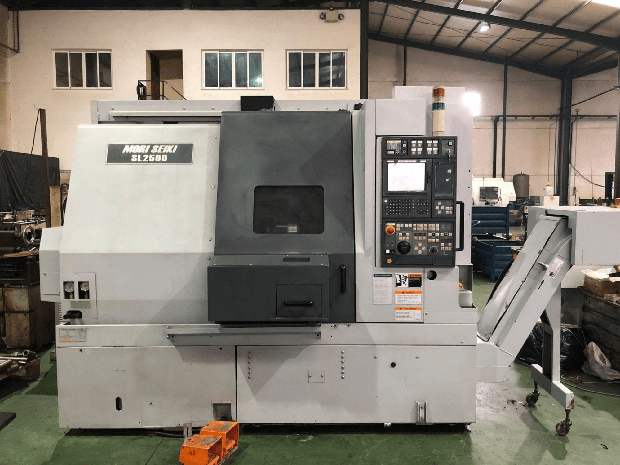 DMG Mori Seiki SL 2500 Y -kääntö-jyrsinkeskus, sivukuva, jossa näkyvät ohjauspaneeli ja lastunkuljetin.