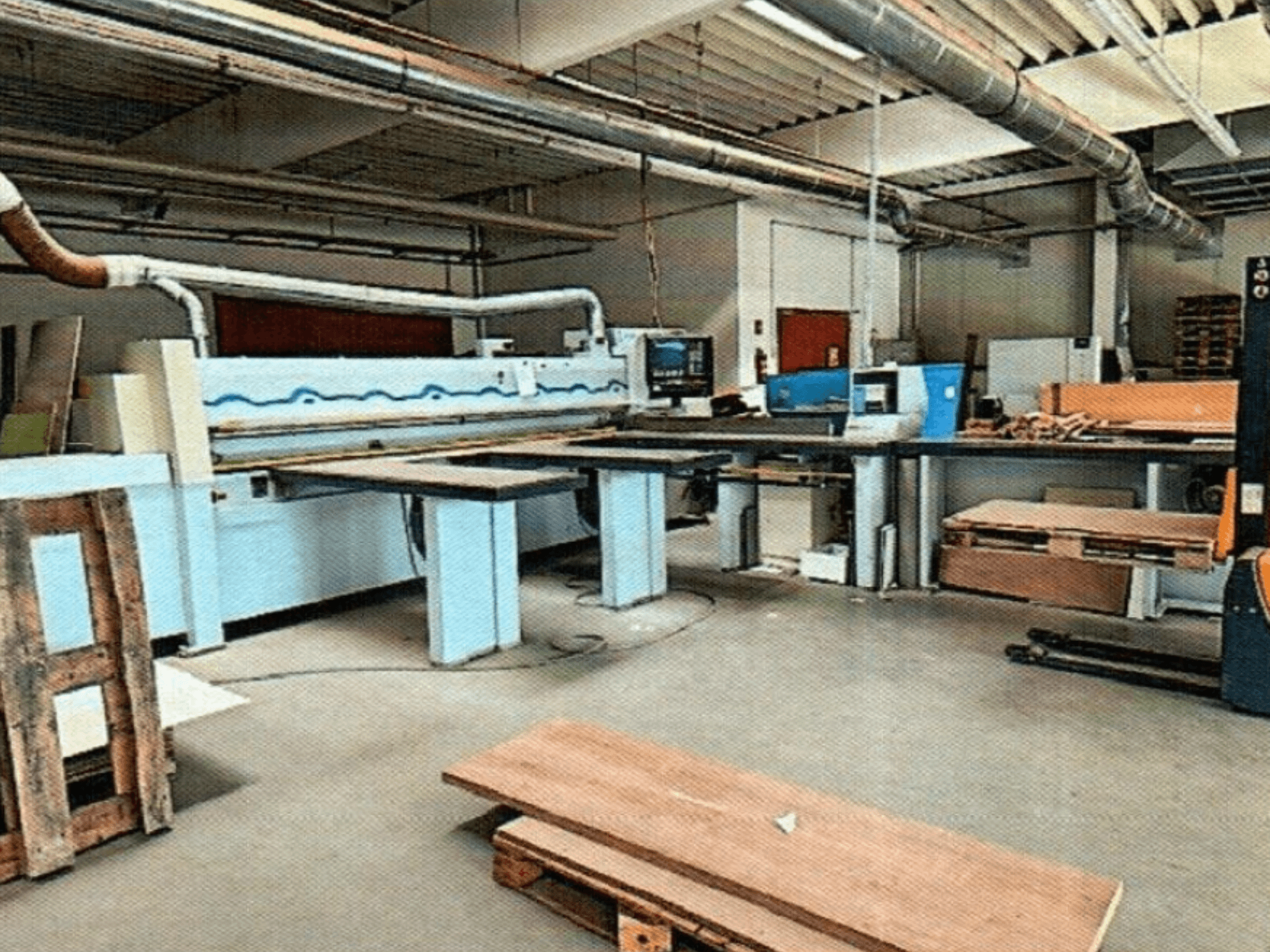 HOMAG HPL 11/38/22 -levysaha työpajassa, jossa on suuri leikkuupöytä ja näyttökonsoli, edestä katsottuna.