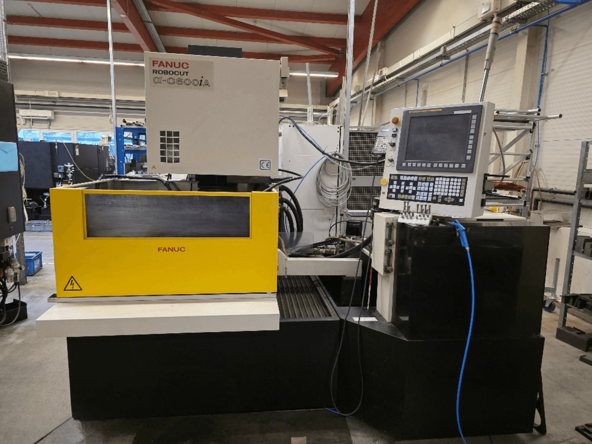 FANUC Robocut α-C600iA -langanleikkauskone, etukuva, keltainen ohjauspaneeli ja digitaalinäyttö.