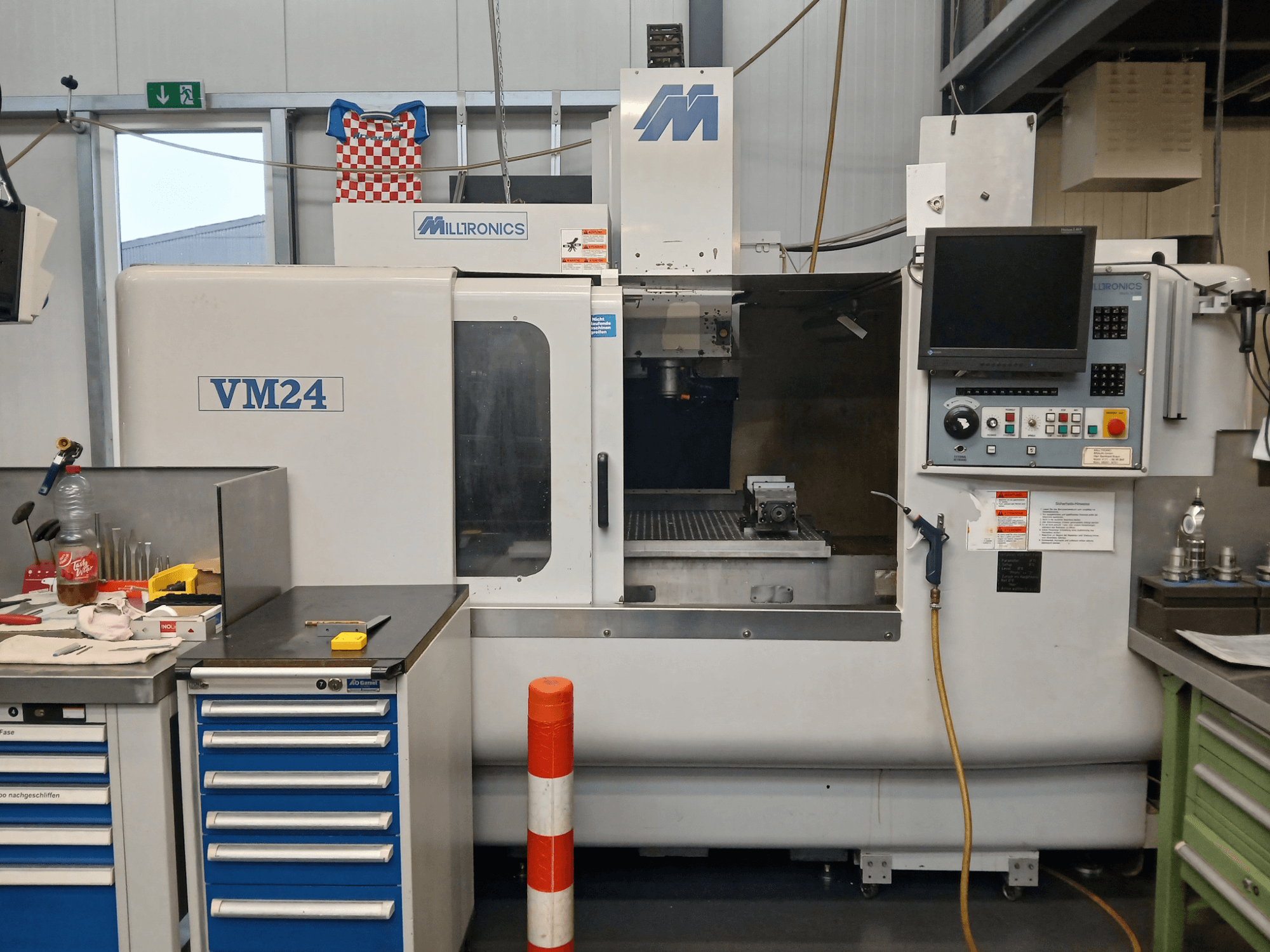 Milltronics VM24 CNC-jyrsinkone edestäpäin, jossa on ohjauspaneeli, työkalujen säilytys ja työskentelyalue.