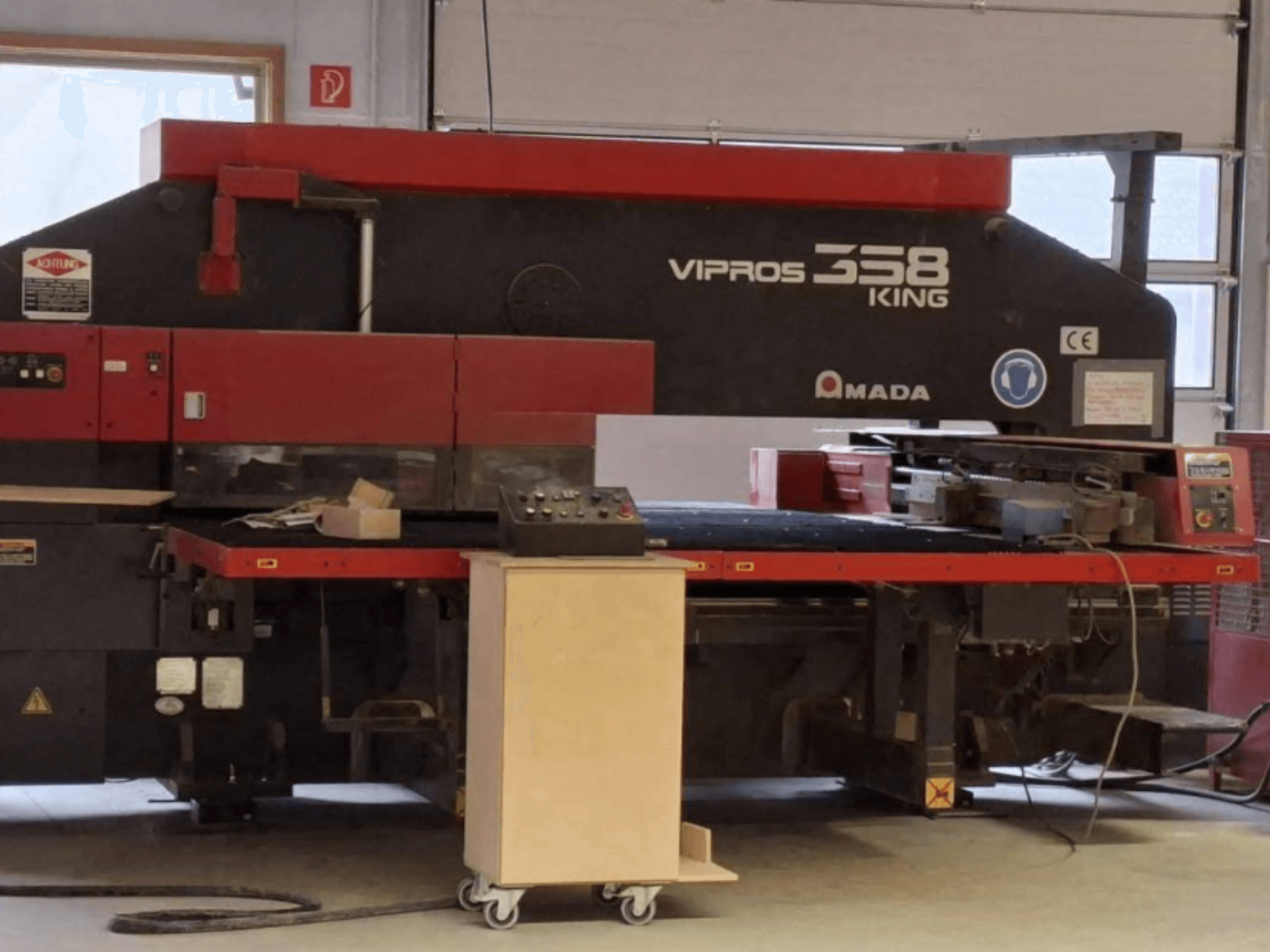 CNC-lävistyskone AMADA VIPROS 358 KING sivulta katsottuna; kuvassa näkyvät ohjauspaneeli ja työkalujen säilytystila.