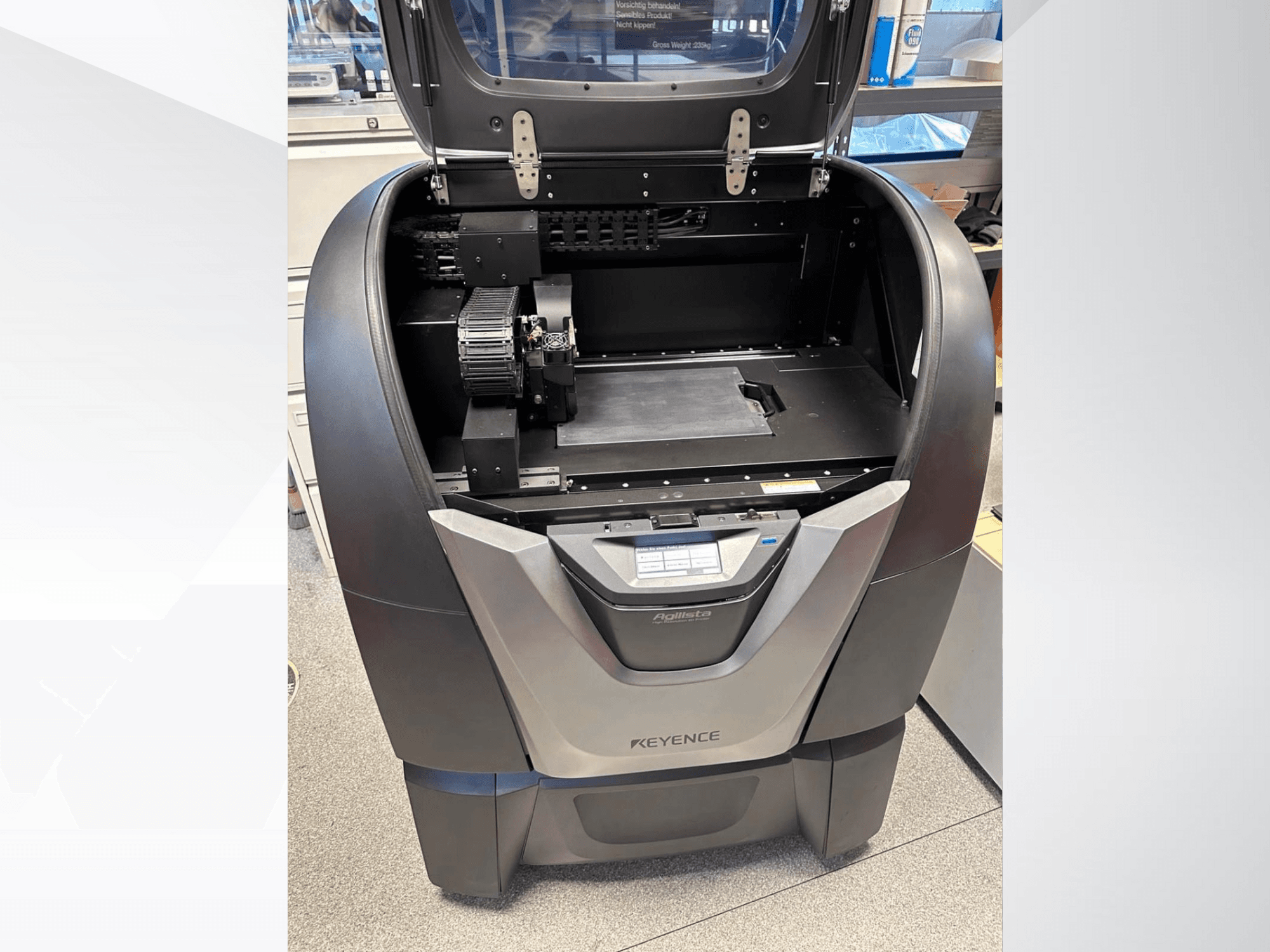 KEYENCE Agilista 3D-tulostin, etukuva, josta näkyy avoin yläosa, suuri rakennusalusta ja sisäiset mekaaniset komponentit.