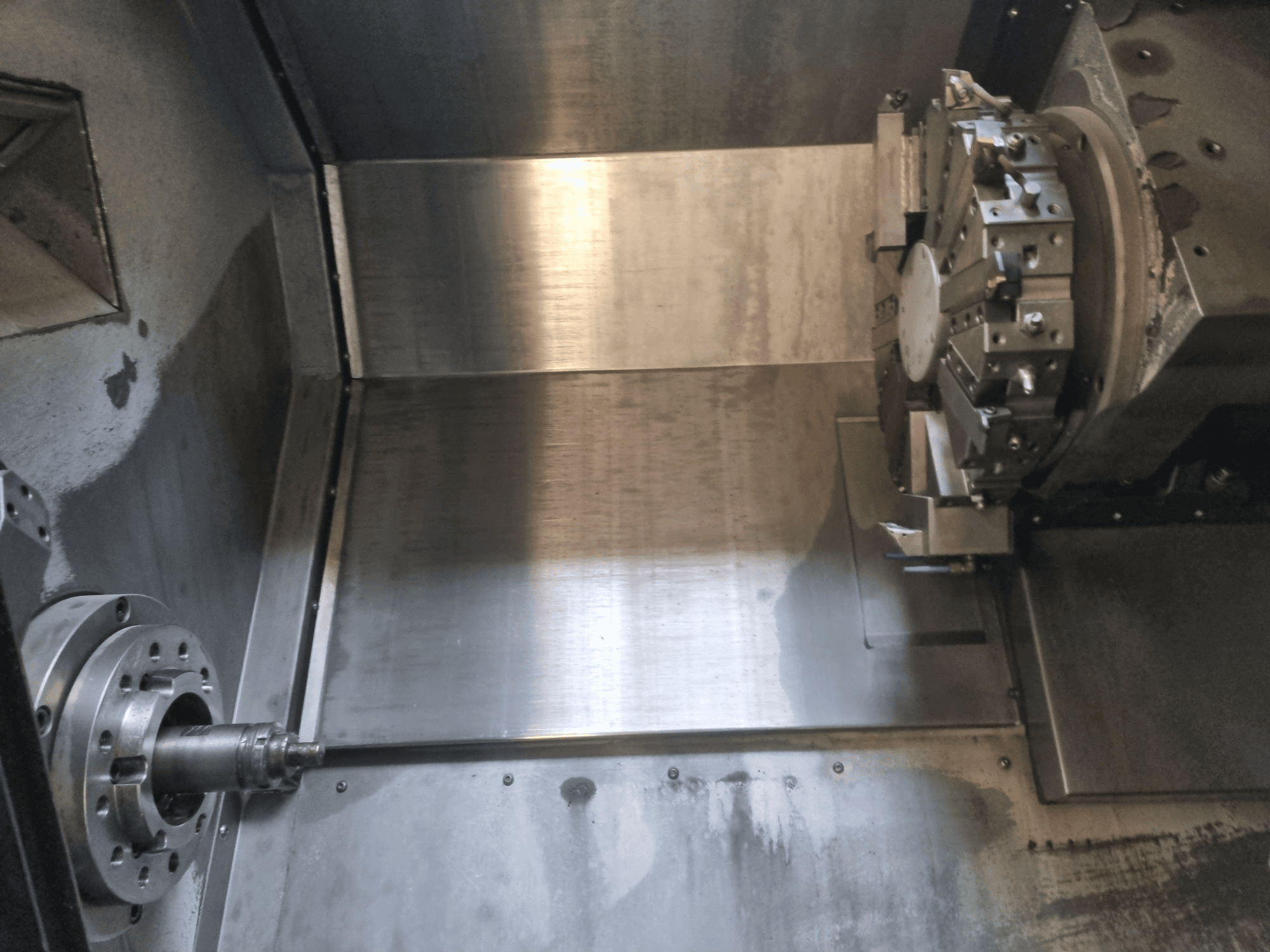 Sisäkuva CNC-sorvista, jossa on pyörivä kara ja metallinen työpinta ja joka esittelee teollista tarkkuustekniikkaa.