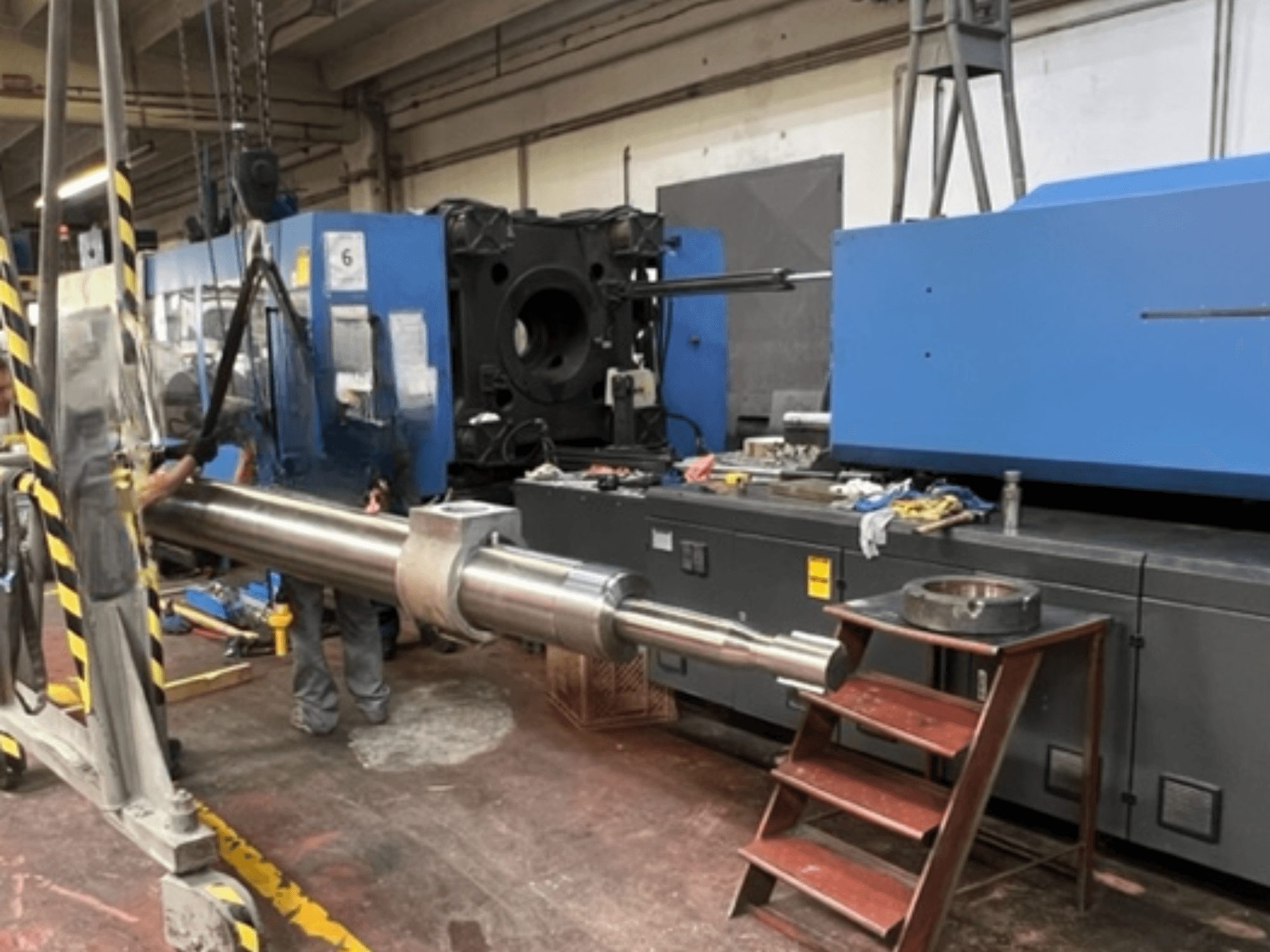 HAITIAN SA8000 -hydraulinen ruiskuvalukone, sivukuva, jossa suurta hydraulista mäntää nostetaan.