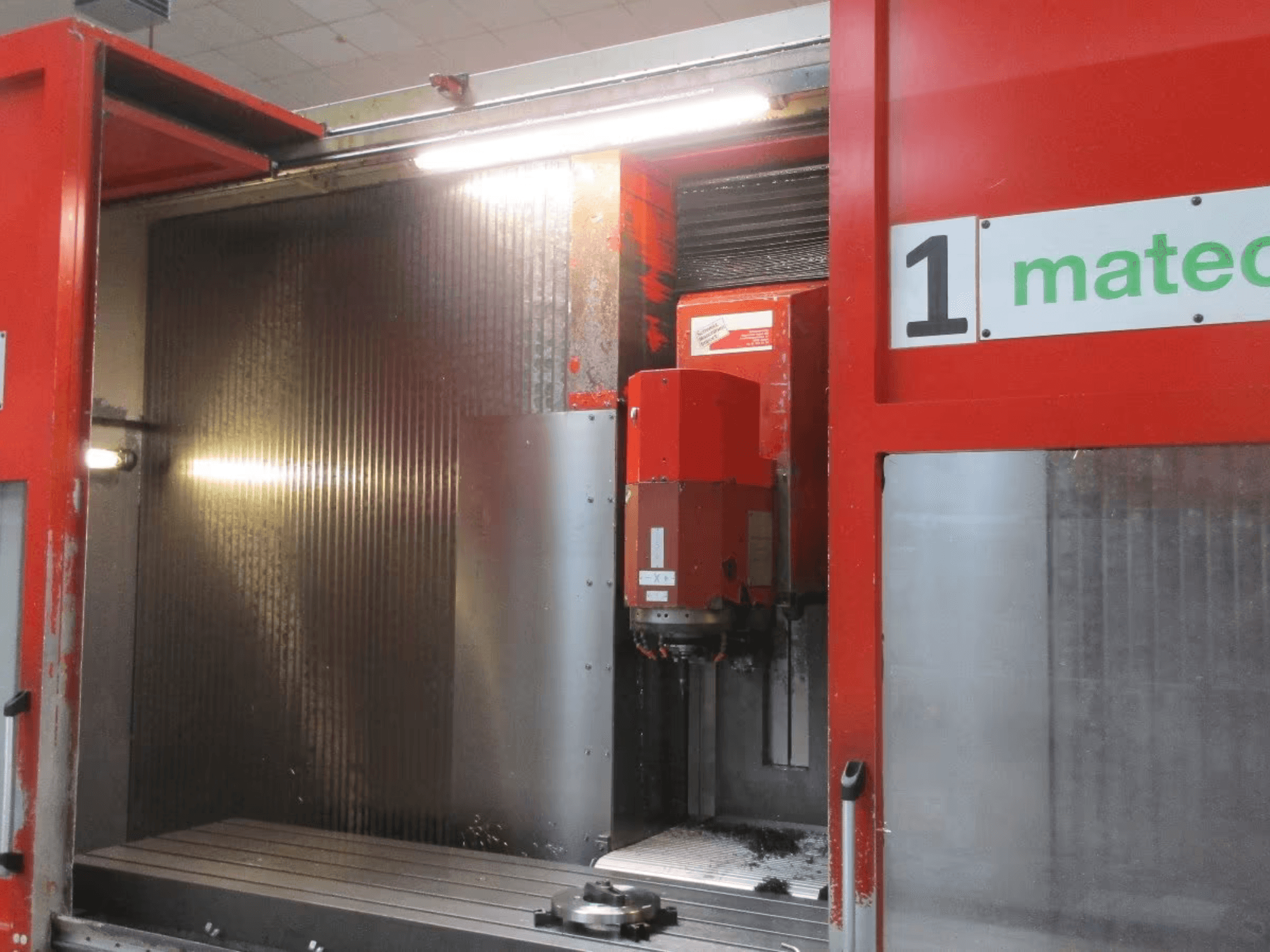 Etukuva Matec 30 HV CNC-pystytyöstökeskuksesta, jossa on näkyvissä leikkuutyökalu, metallipinta ja koneen sisätilojen yksityiskohdat.