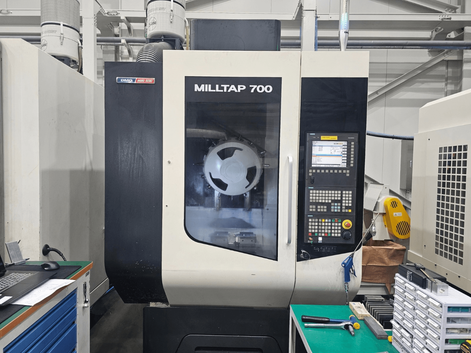 DMG MORI MILLTAP 700 -pystykoneistuskeskus, etunäkymä, jossa näkyvät ohjauspaneeli, kara ja työtilan yksityiskohdat.
