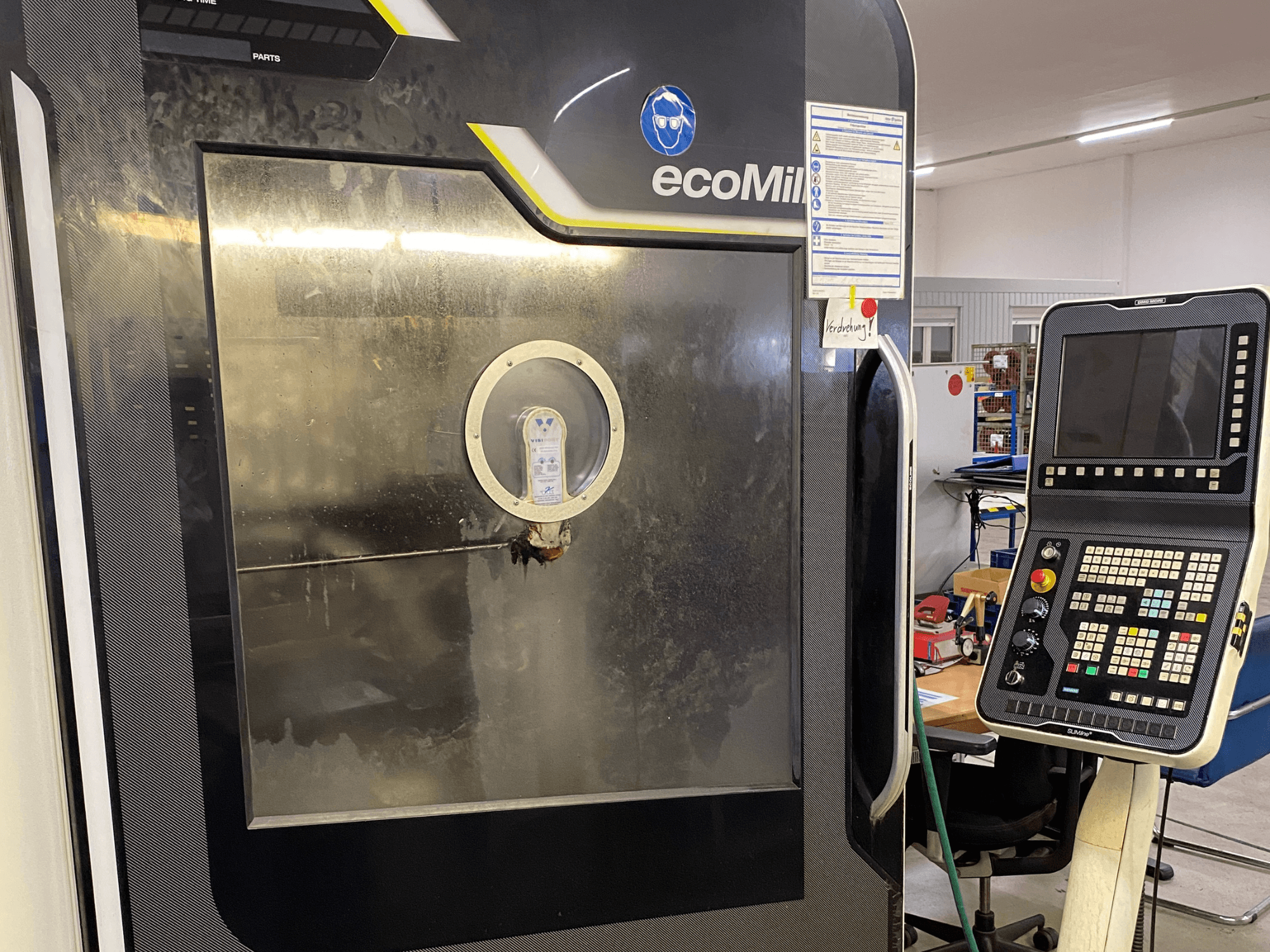 DMG MU 70 ECO -jyrsin edestä katsottuna; oikealla on ohjauspaneeli ja lasilevy, jonka läpi näkyvät laitteen sisäosat.