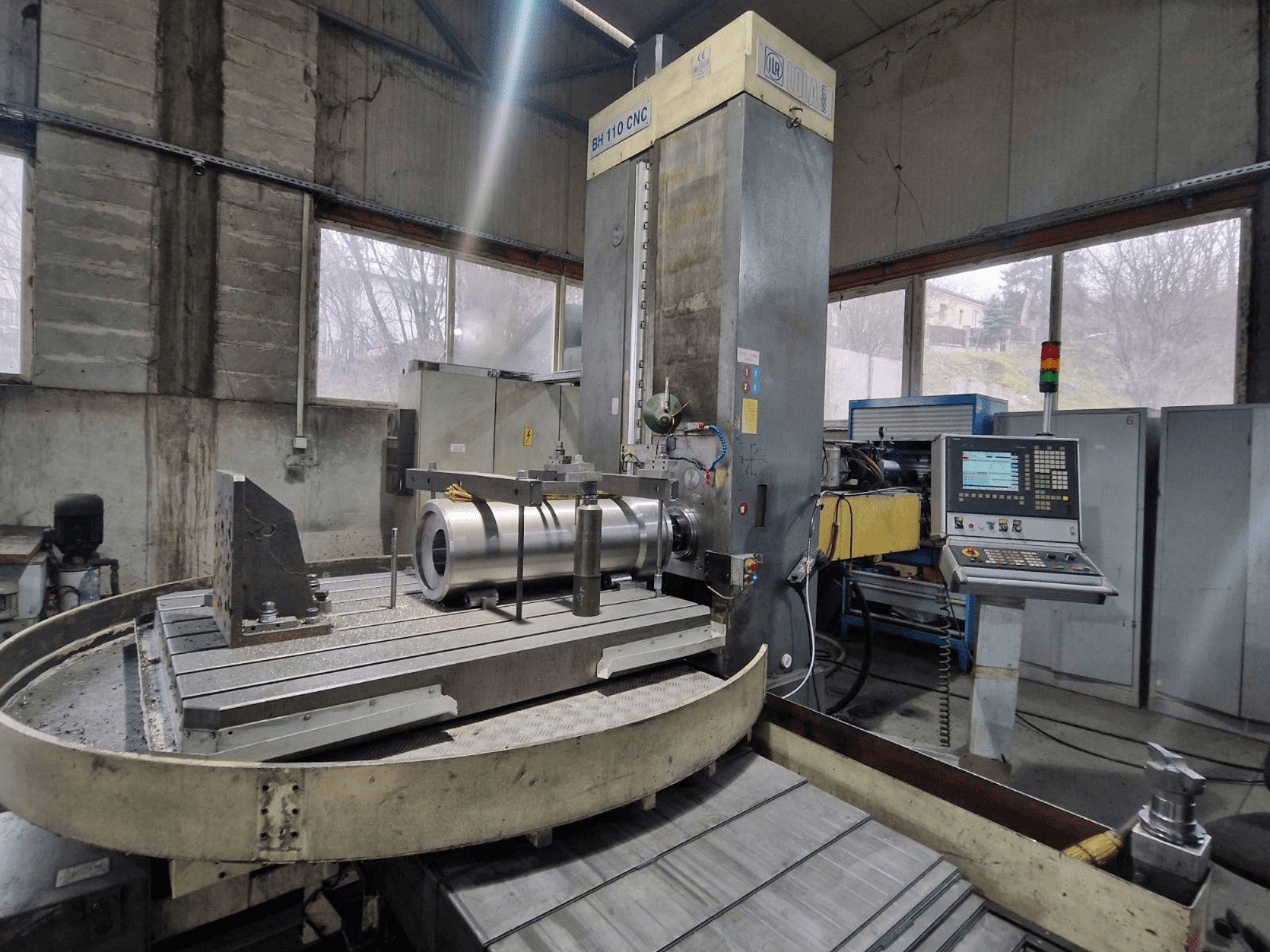 LOLA BH 110 CNC-porakone työpajassa, etukuva, jossa on metallityökappale ja ohjauspaneeli.
