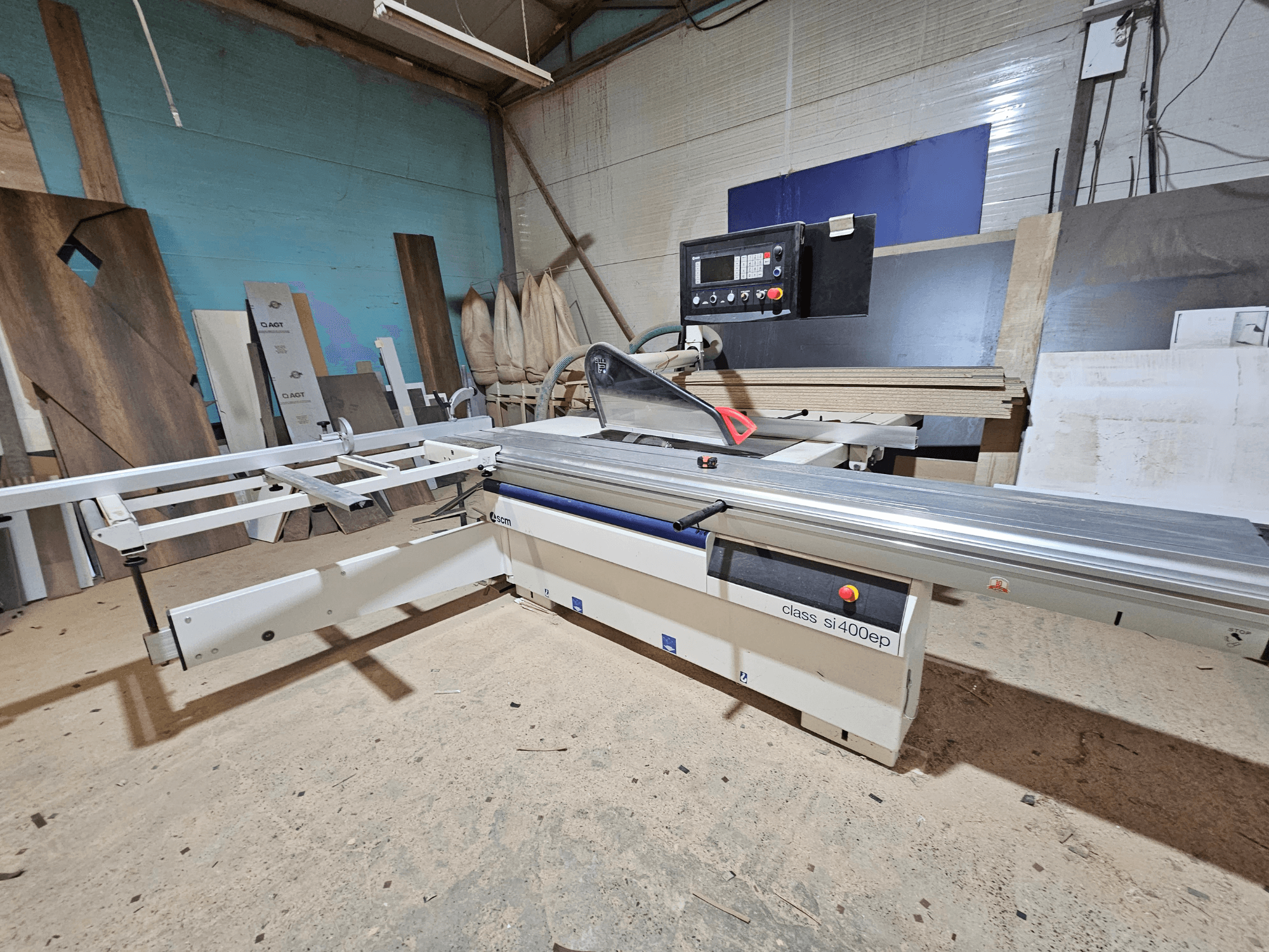 SI400EP-luokan levysaha, etukuva, säädettävällä aidalla, asetettu hiekkapintaiselle työpajan lattialle, puulevyjen ympäröimänä.