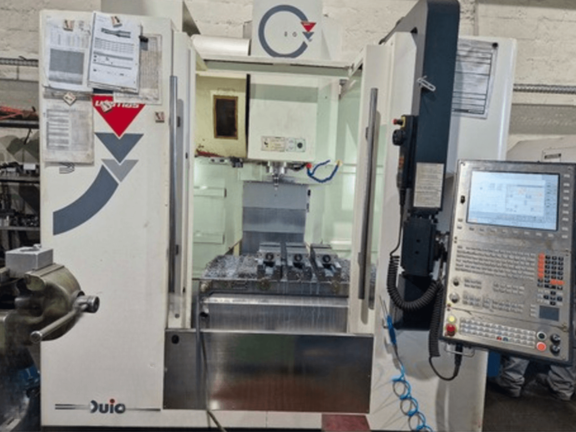 Etunäkymä WEMAS VZ 860 -pystytyöstökeskuksesta, jossa on ohjauspaneeli ja CNC-käyttöliittymä, sekä siihen liitetyt paperit.