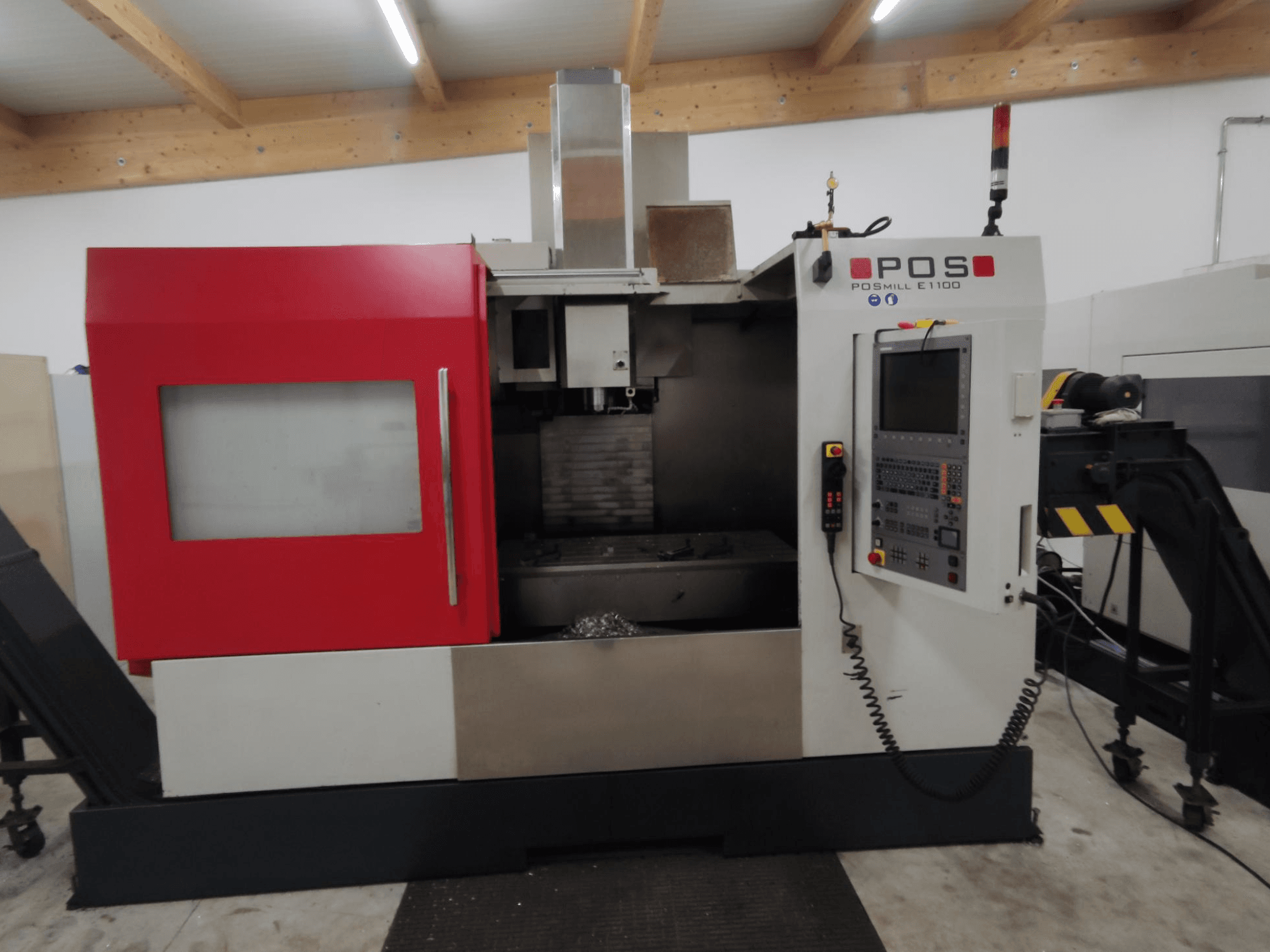 POS POSMILL E1100 CNC-jyrsinkone etukuvassa, jossa on punainen kotelo, ohjauspaneeli ja turvavalo päällä.