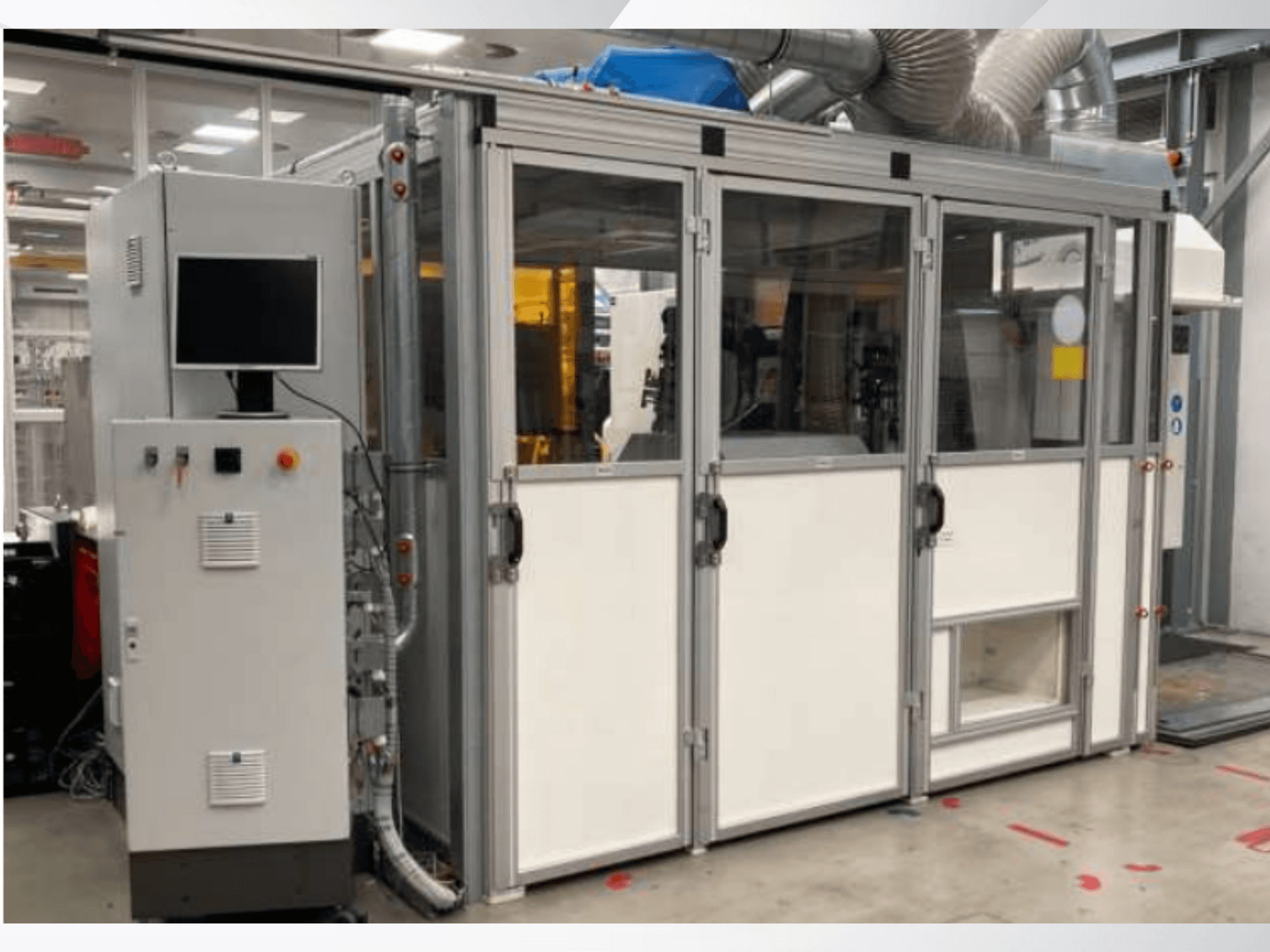 Teollisuuskone, jossa on ohjauspaneeli, etukuva; siinä on lasiovet, ilmanvaihtokanavat ja näkyvät johdot.
