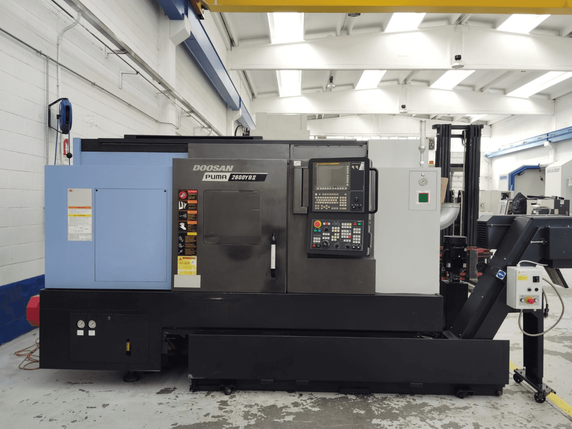 DOOSAN Puma 2600YB II -vaakakääntökoneen etukuva, jossa ohjauspaneeli ja turvatarrat näkyvissä.