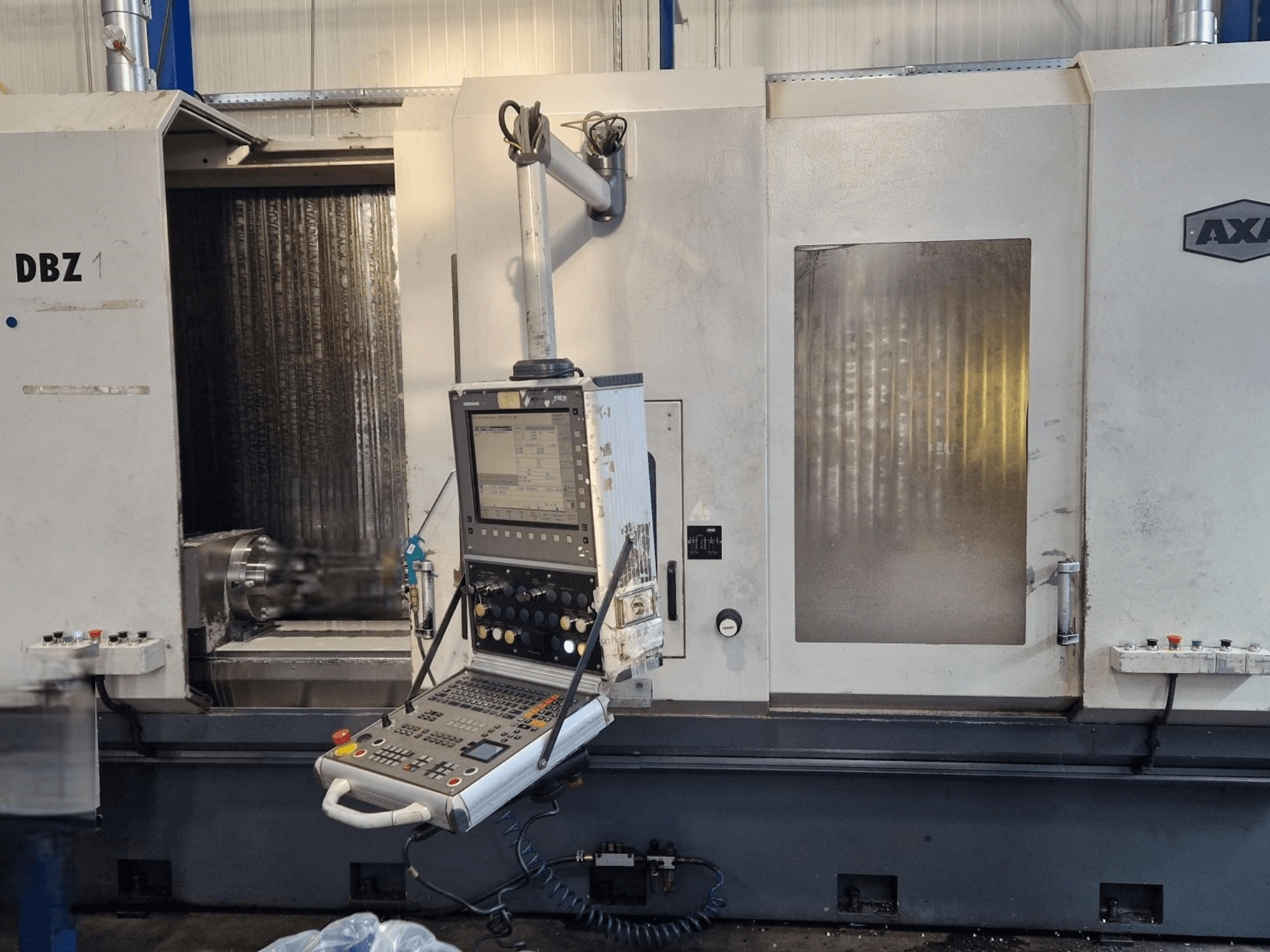 AXA DBZ -pystytyöstökeskus kuvattuna vinosta etukuvasta, jossa on ohjauspaneeli ja näkyvä leikkuutyökalualue.