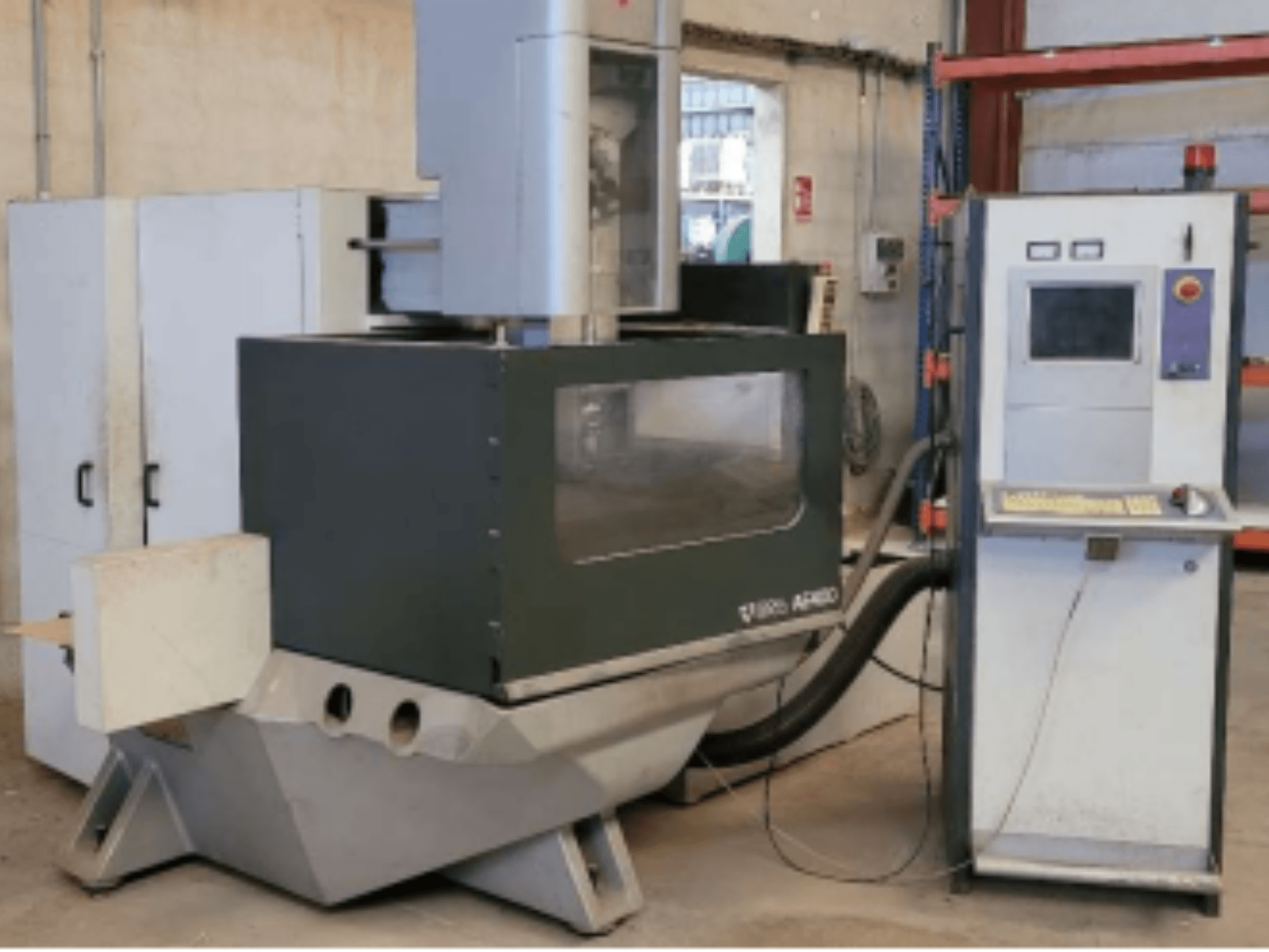 ONA AE 400 Wire EDM -kone työpajassa, jossa oikealla on ohjauspaneeli ja suuri leikkausalue.