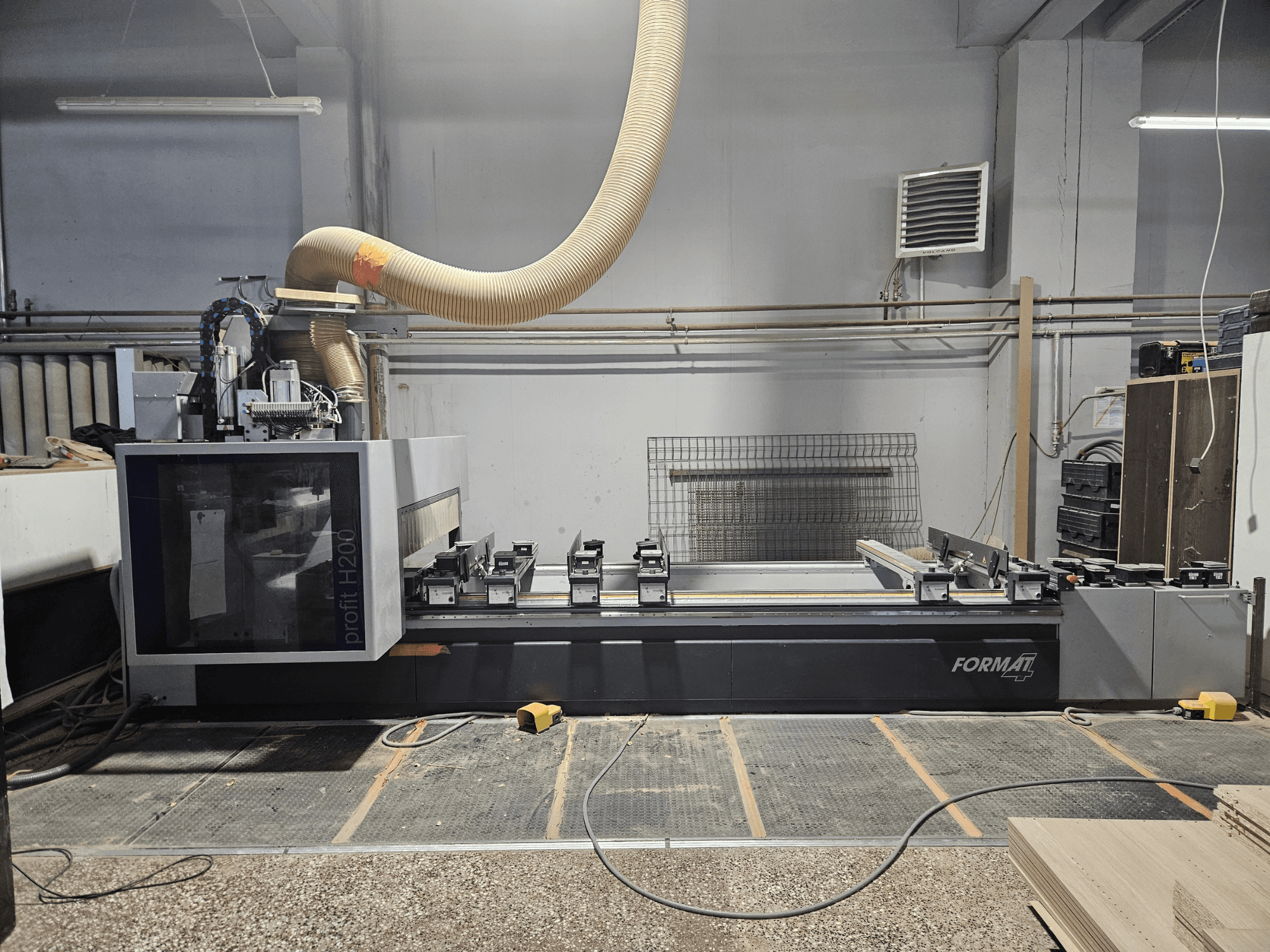 FORMAT profit H200 CNC-kone työpajassa, sivukuva, jossa näkyy työtaso ja pölynpoistojärjestelmä.