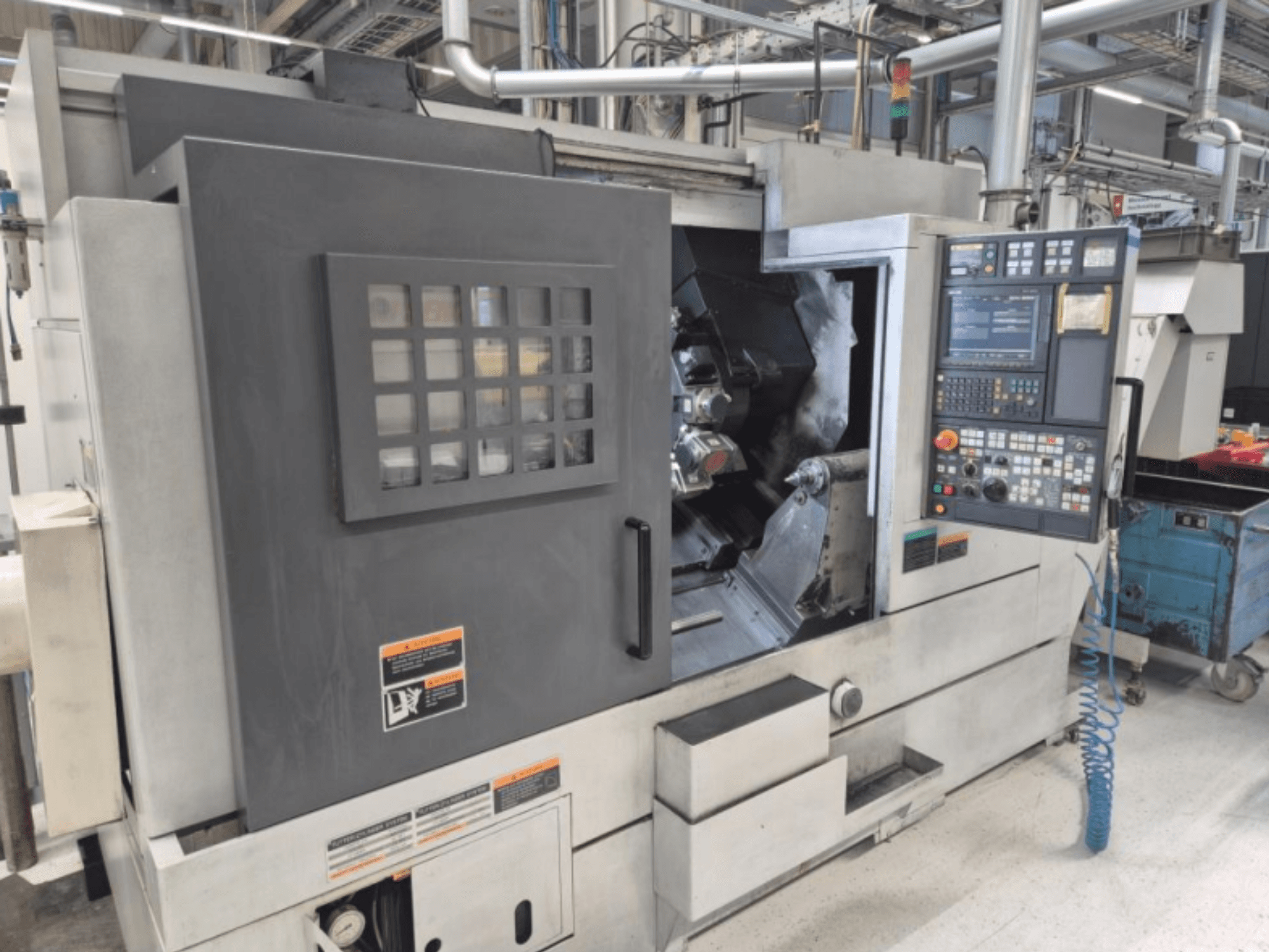 CNC-sorvi ja ohjauspaneeli, etukuva. Sisältää näkyvän työalueen ja turvaikkunan, merkki tuntematon.