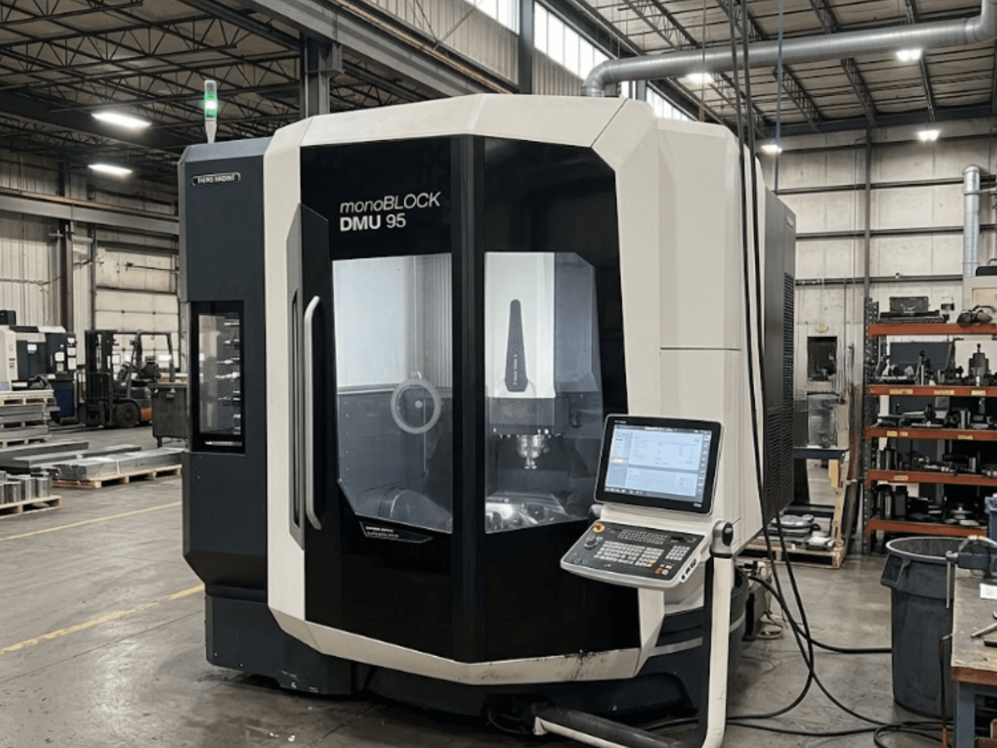 DMG MORI DMU 95 Monoblock -pystykoneistuskeskus tehtaassa, ohjauspaneeli näkyvissä, etunäkymä.