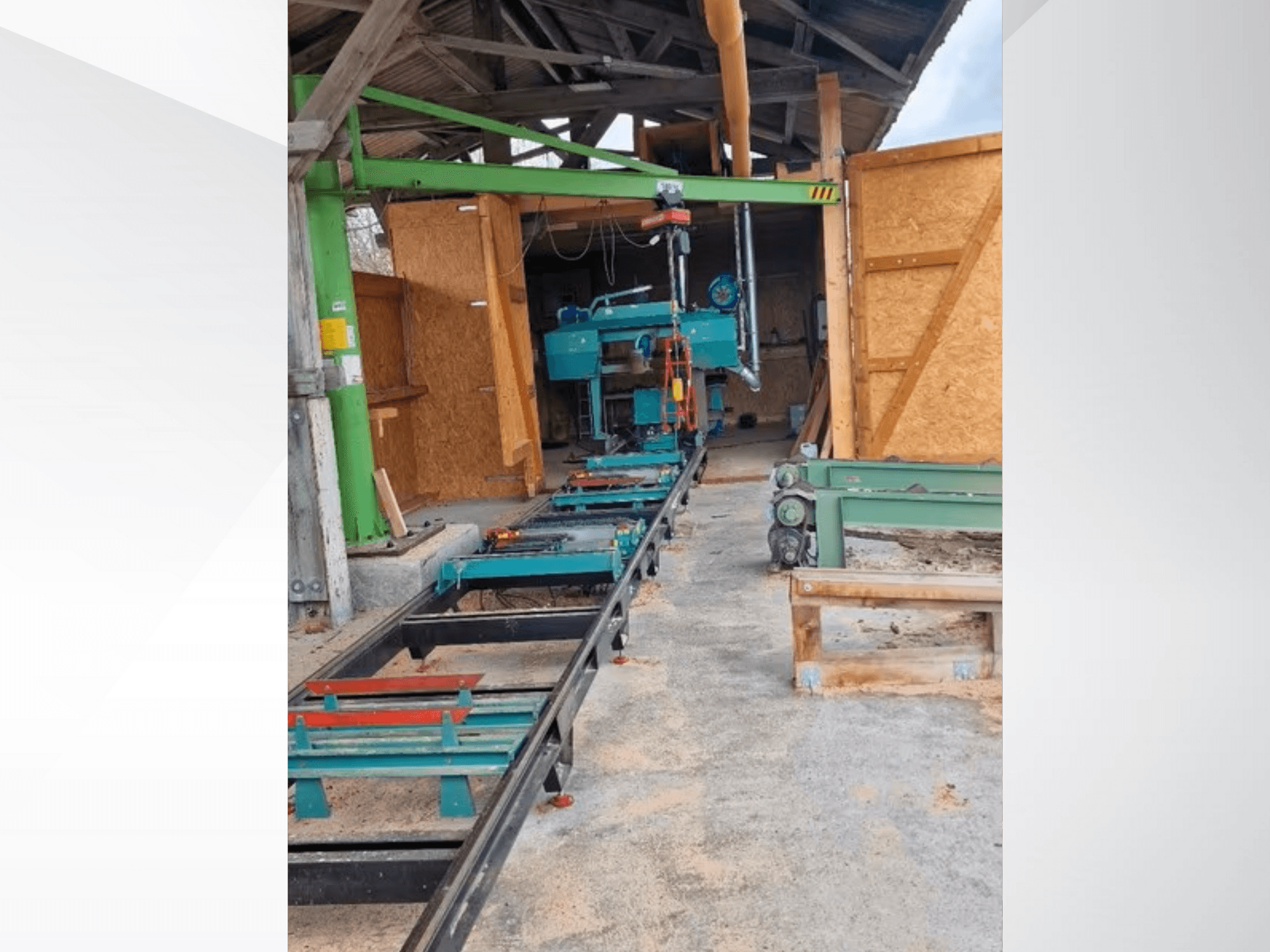 Vaakasuora vannesahakone korjaamolla, edestä katsottuna. Varusteisiin kuuluu kisko ja vihreitä lisävarusteita.