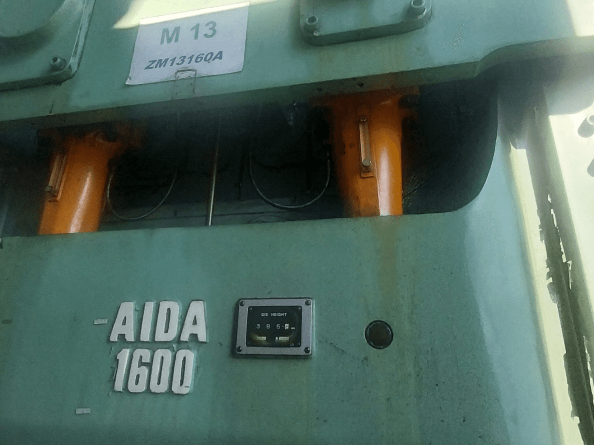 AIDA NC2-1600 mekaaninen leimauspuristin, etukuva; oranssit hydrauliset komponentit ja muotin korkeusmittari näkyvissä.