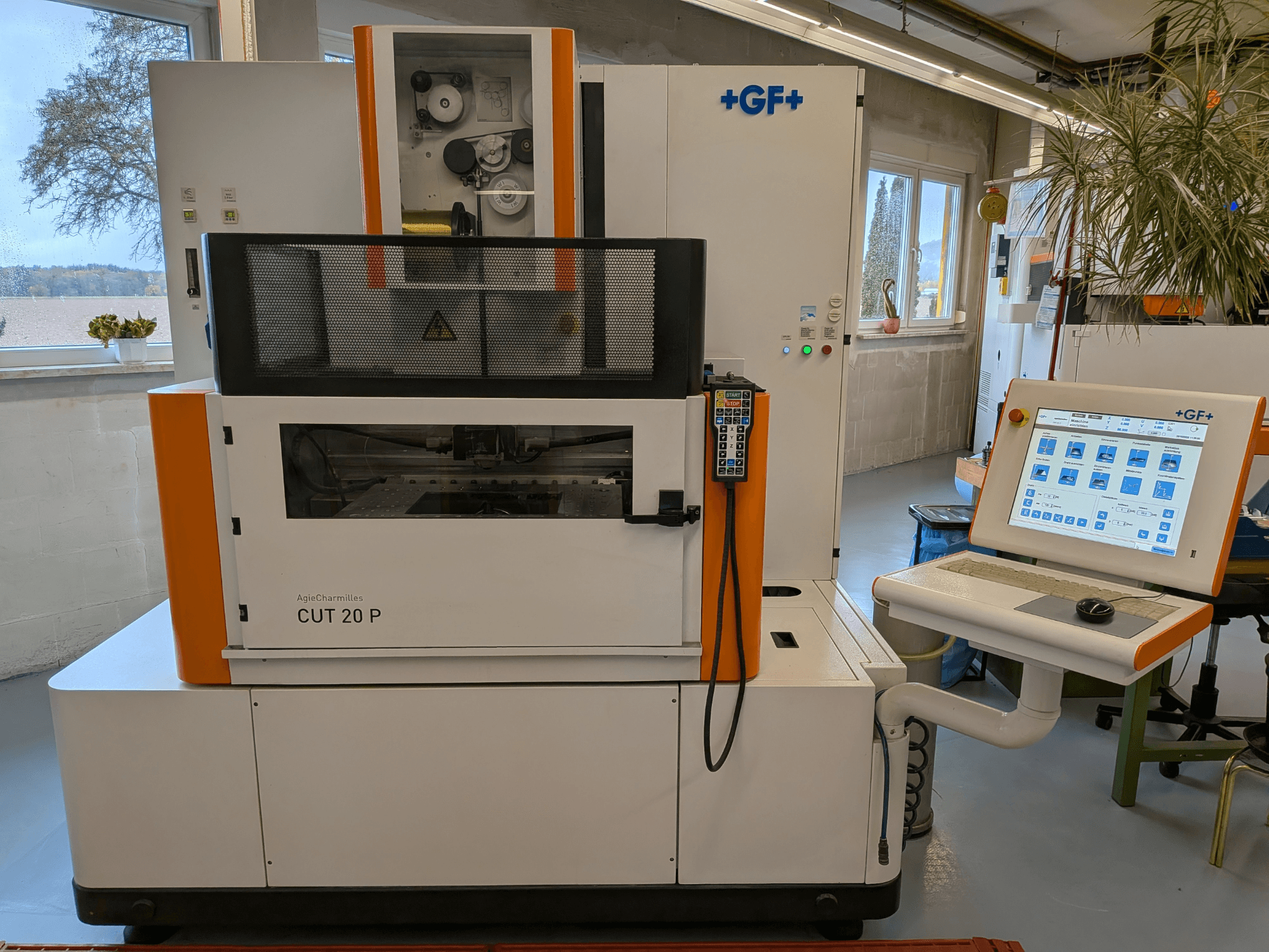 AgieCharmilles Cut-20 P -lanka-EDM-kone edestä katsottuna ohjauspaneelin ja näytön kera, sijoitettuna valoisaan työpajaan.