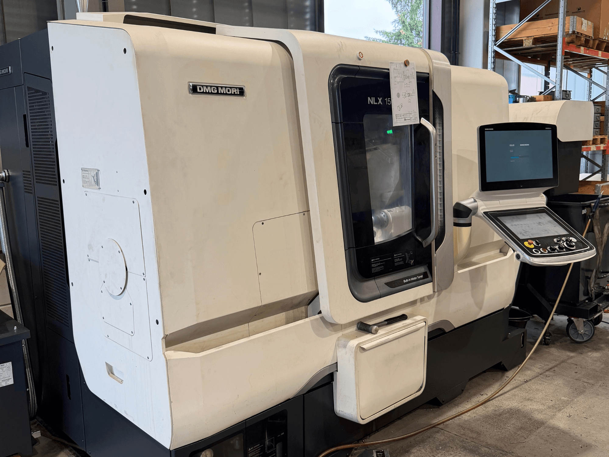 DMG MORI NLX1500MC/500 -vaakasuoran sorvin etunäkymä, jossa ohjauspaneeli ja karan alue näkyvät läpinäkyvän suojakannen läpi.