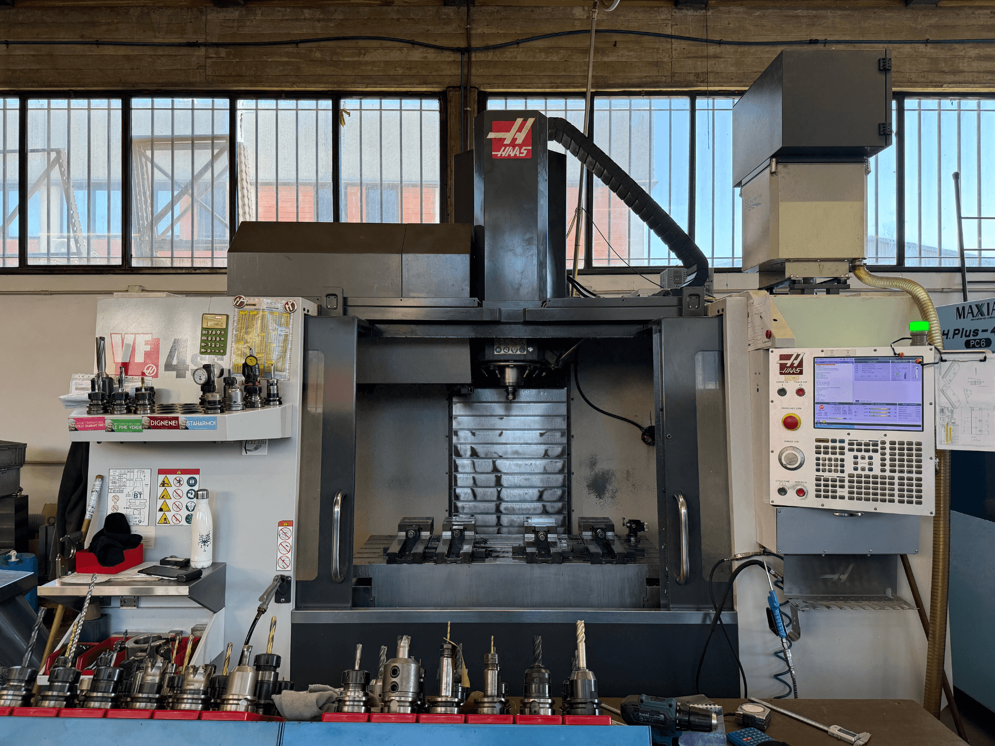 HAAS VF-4SS -pystykoneistuskeskus, etunäkymä, jossa näkyvät ohjauspaneeli, työkalunpitimet ja karan alue.