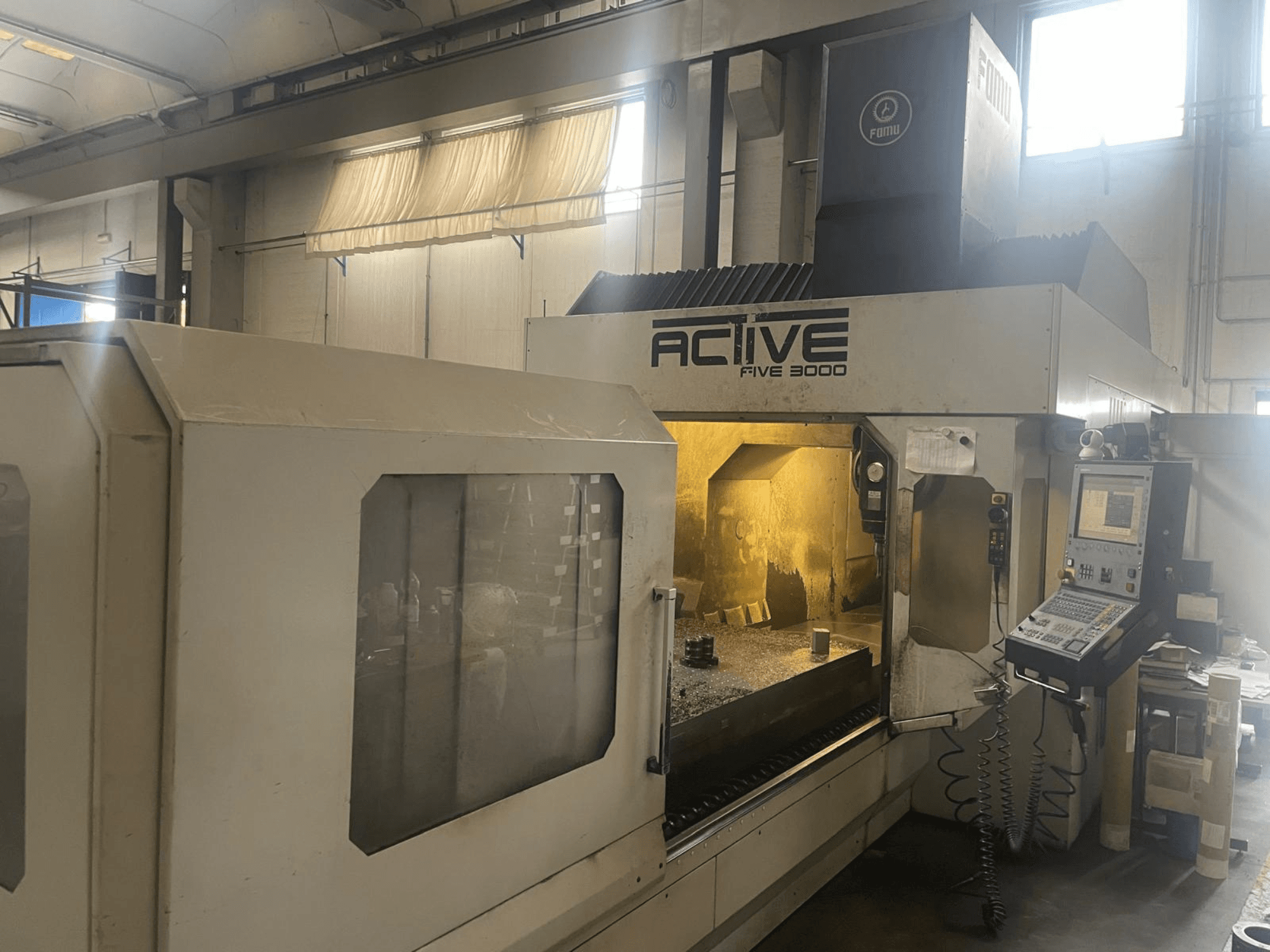 ACTIVE Five 3000 CNC -koneen etukuva, jossa näkyy ohjauspaneeli ja työalue, jonka sisällä on osittain työstetty kappale.