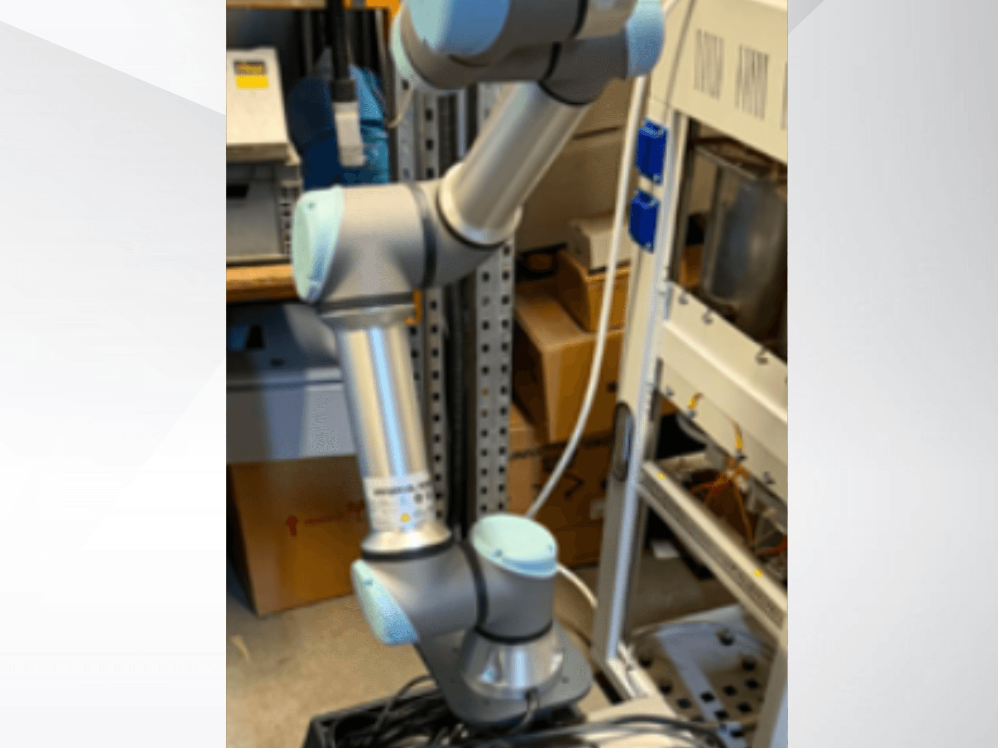 Universal Robotsin UR5e-robottivarsi sivulta katsottuna; kuvassa näkyvät nivelet, kevyt rakenne ja ohjauskaapelit.