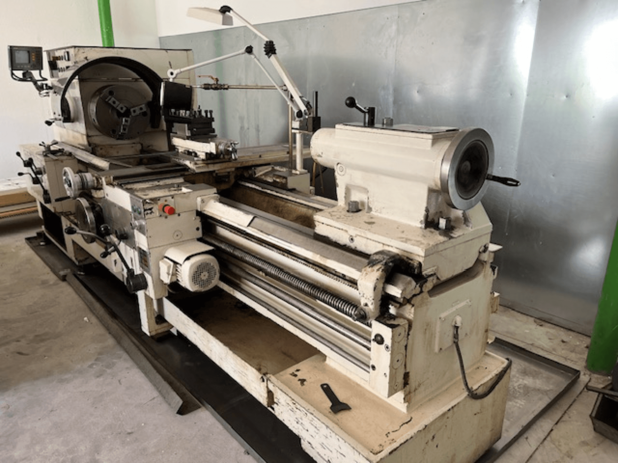 Vintage-metallisorvi, jossa on ohjauspaneeli ja työkaluja, sivukuva, jossa näkyvät käyttöelementit ja metallin viimeistely.