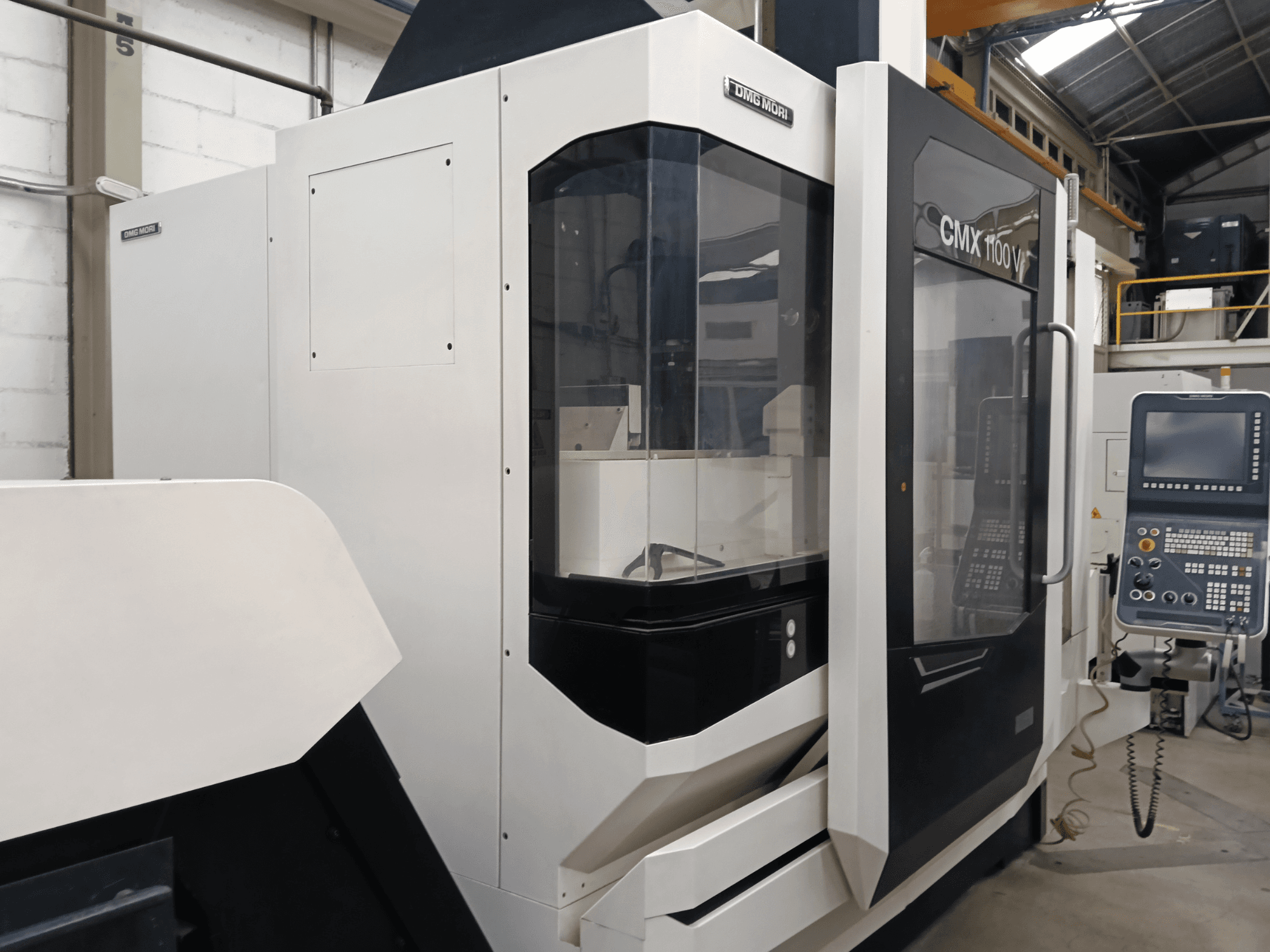 DMG MORI MORI CMX 1100 V -pystykoneistuskeskus, etunäkymä, jossa näkyvät ohjauspaneeli ja lasikotelo.