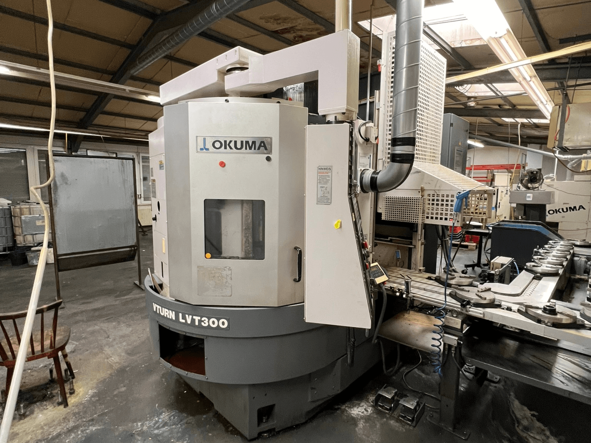 Okuma Vturn LVT300 CNC-sorvi, sivukuva teollisuusympäristössä, jossa näkyy ohjauspaneeli ja jäähdytysjärjestelmä.