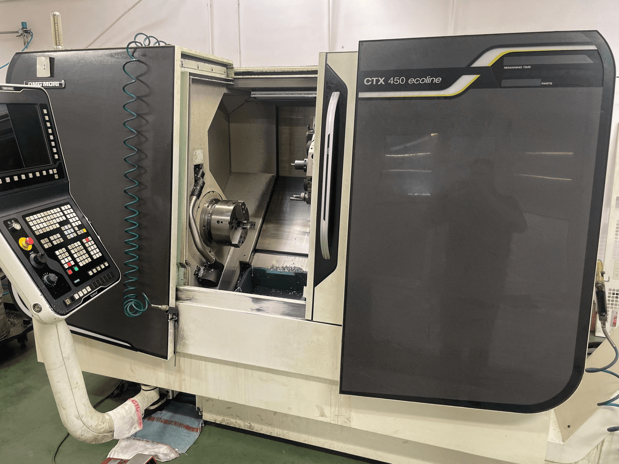 DMG MORI CTX 450 ecoline CNC-kone sivukuvassa, jossa näkyy ohjauspaneeli, ruuvipuristin ja työstöalue.