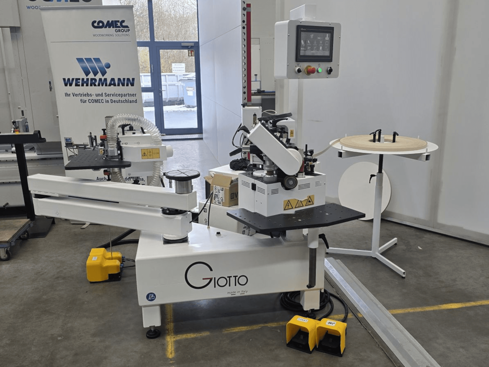 Giotto puunjalostuskone ohjauspaneelilla, sivukuva, sisältää jalkapolkimet ja pyörivän työtason.