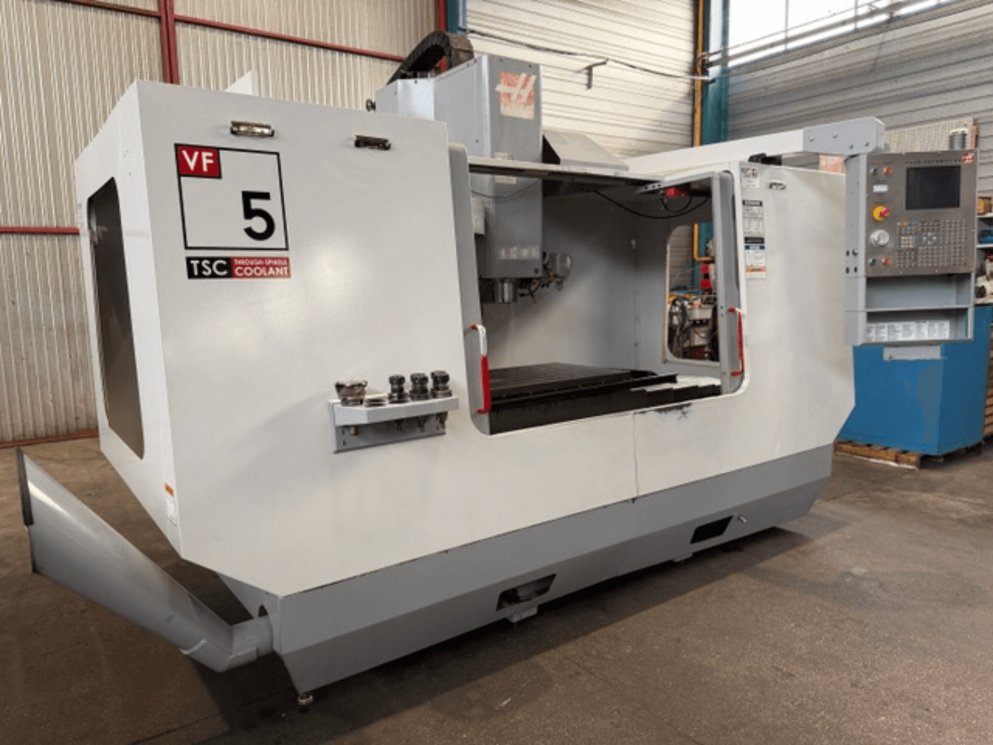 HAAS VF5-HE -pystykoneistuskeskus, etunäkymä, jossa näkyvät TSC-jäähdytysnestejärjestelmä ja käyttäjän ohjauspaneeli.