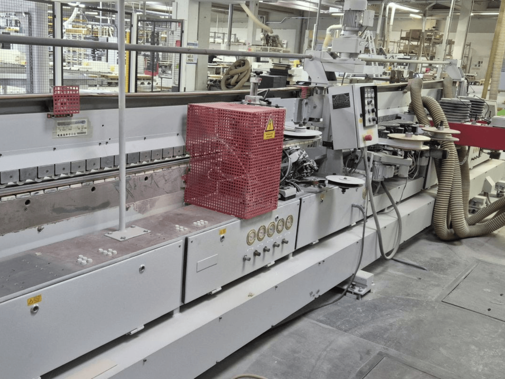 Reunanauhakone, jossa on ohjauspaneeli, imuletkut ja punainen suojakansi sivukulmasta katsottuna.