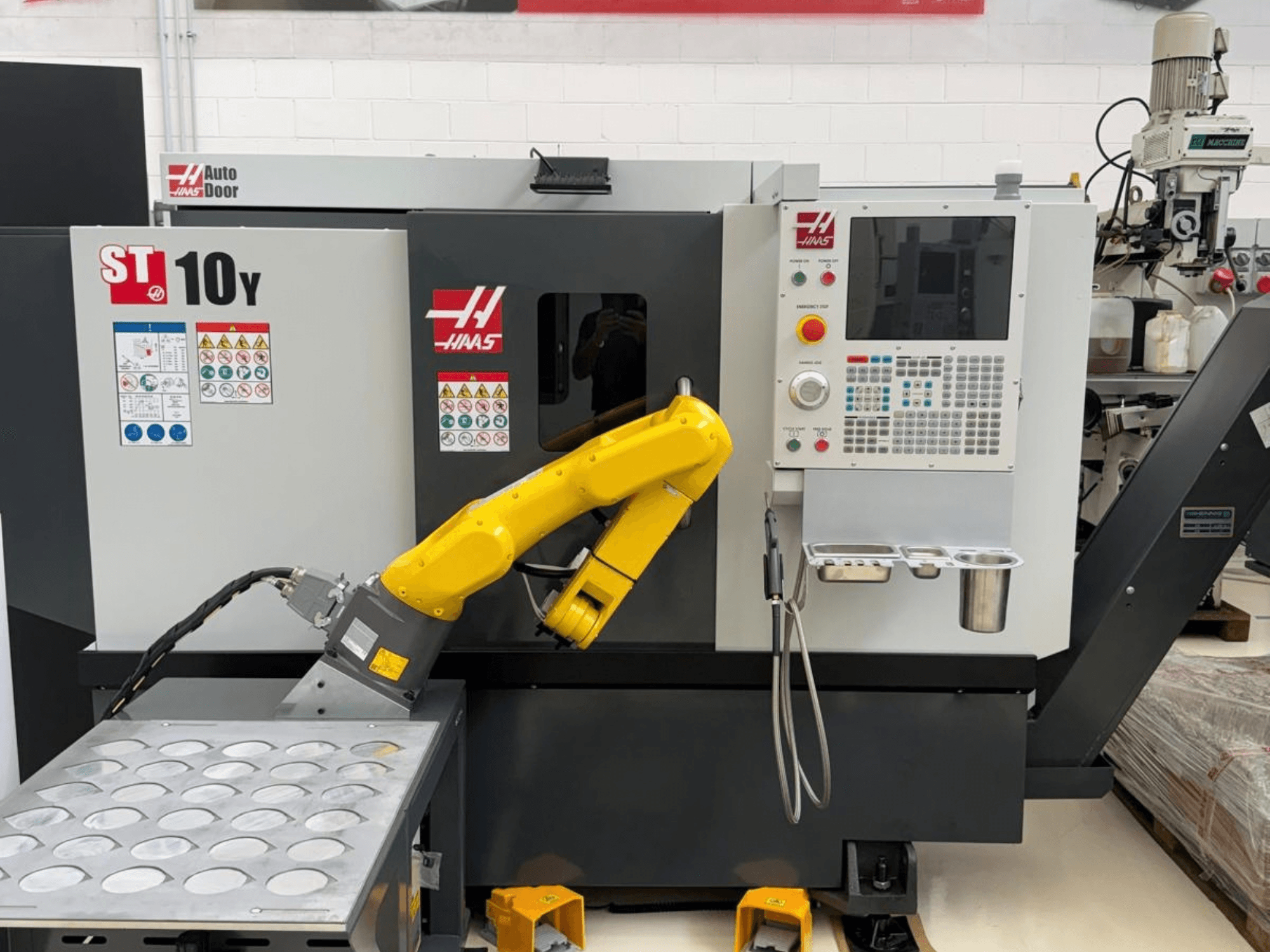 Haas ST-10Y -vaakasuora sorvi edestä katsottuna; kuvassa näkyy robottivarsi sekä ohjauspaneeli, jossa on työkalupidikkeiden lokerot.
