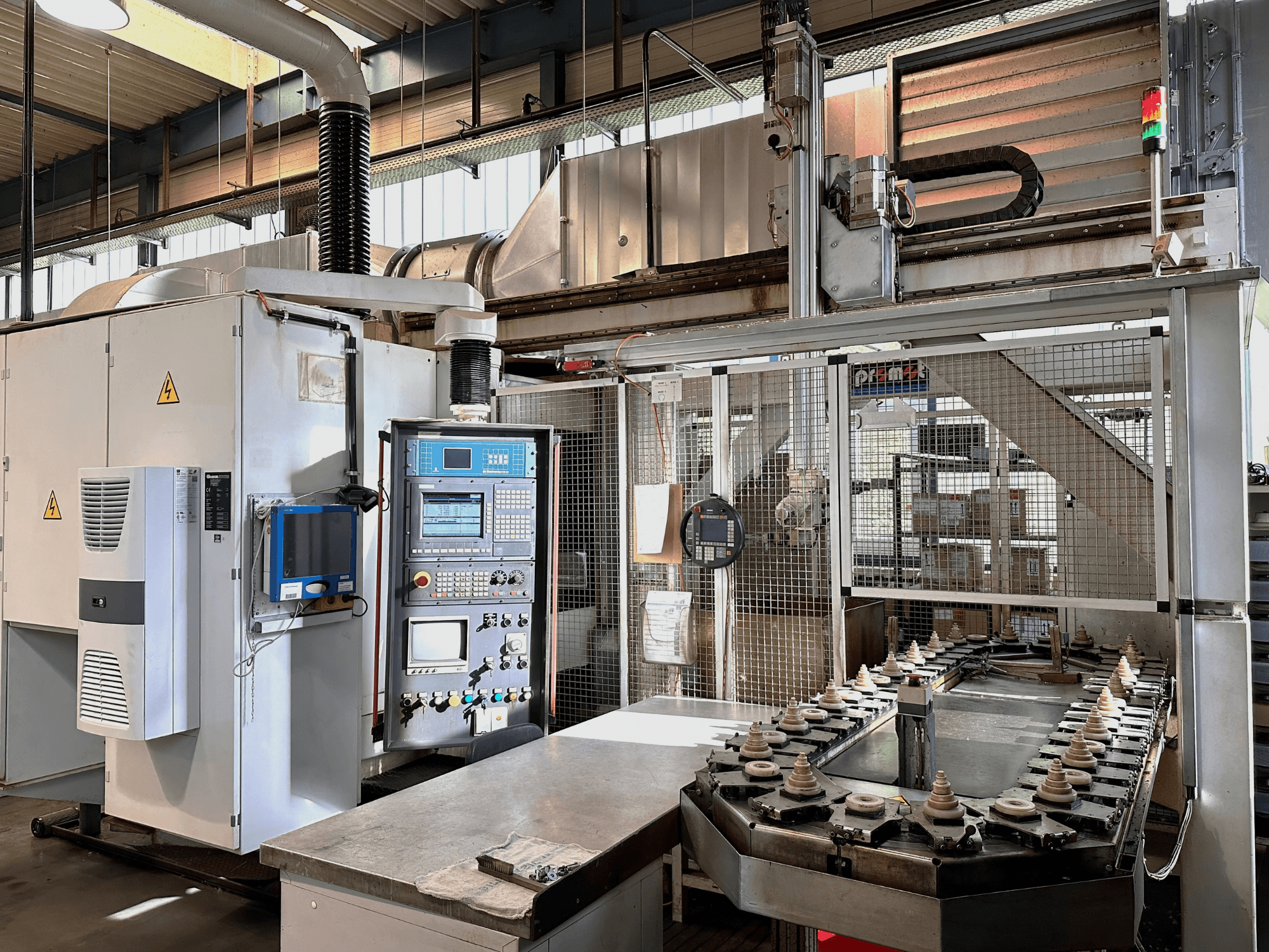 Teollisuuskone, jossa on ohjauspaneeli, jäähdytysyksikkö ja kuljetin. Etunäkymä, jossa on kirkkaat valot ja turvamerkinnät.