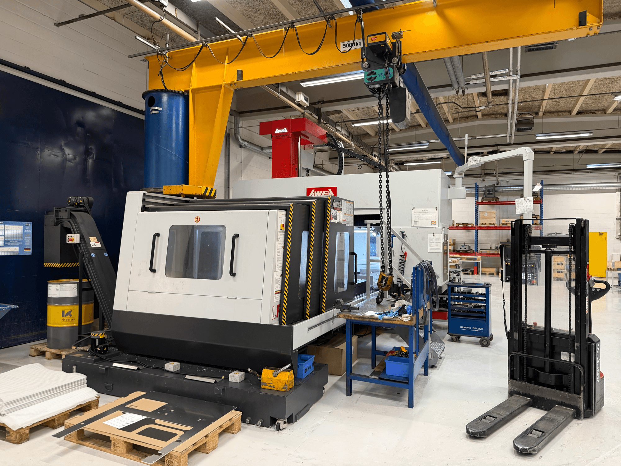 Gantry-jyrsinkone AWEA LP3016YF, etukuva, taustalla työkalut, sininen säiliö ja työtila.