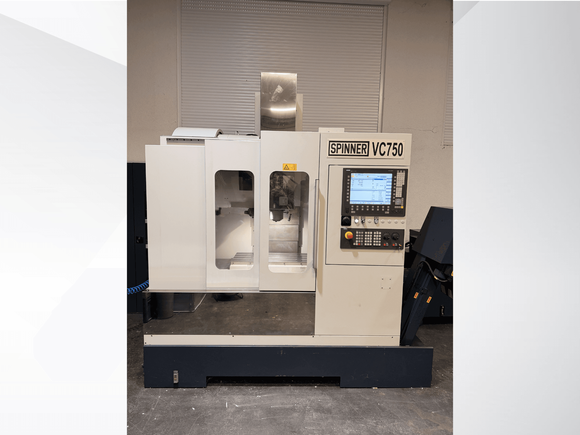 Spinner VC750 CNC-kone edestä katsottuna, jossa on ohjauspaneeli, työstöalue ja jäähdytysjärjestelmä.