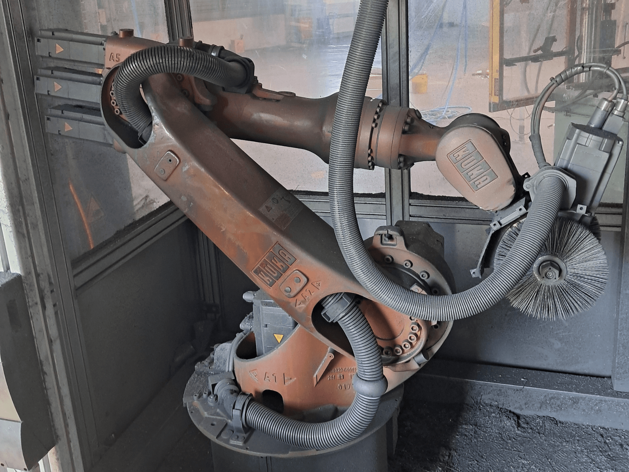 KUKA KR 16-2 -robottivarsi sivulta katsottuna; kuvassa näkyvät kaapelit, harjat ja mekaaniset liitokset työympäristössä.