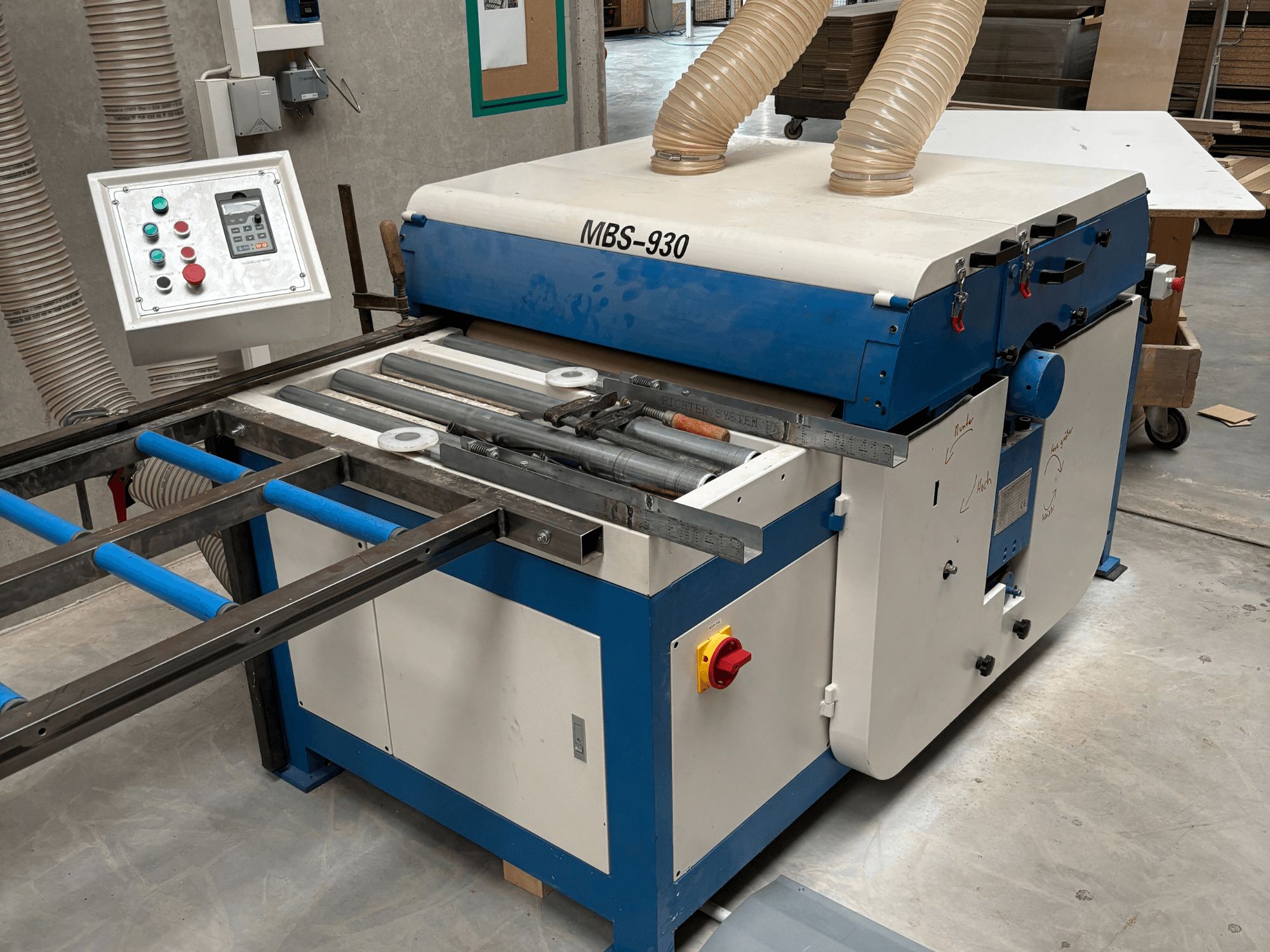 MBS-930 puuntyöstökone ohjauspaneelilla ja teloilla, sivulta katsottuna, pölynpoistoletkut.