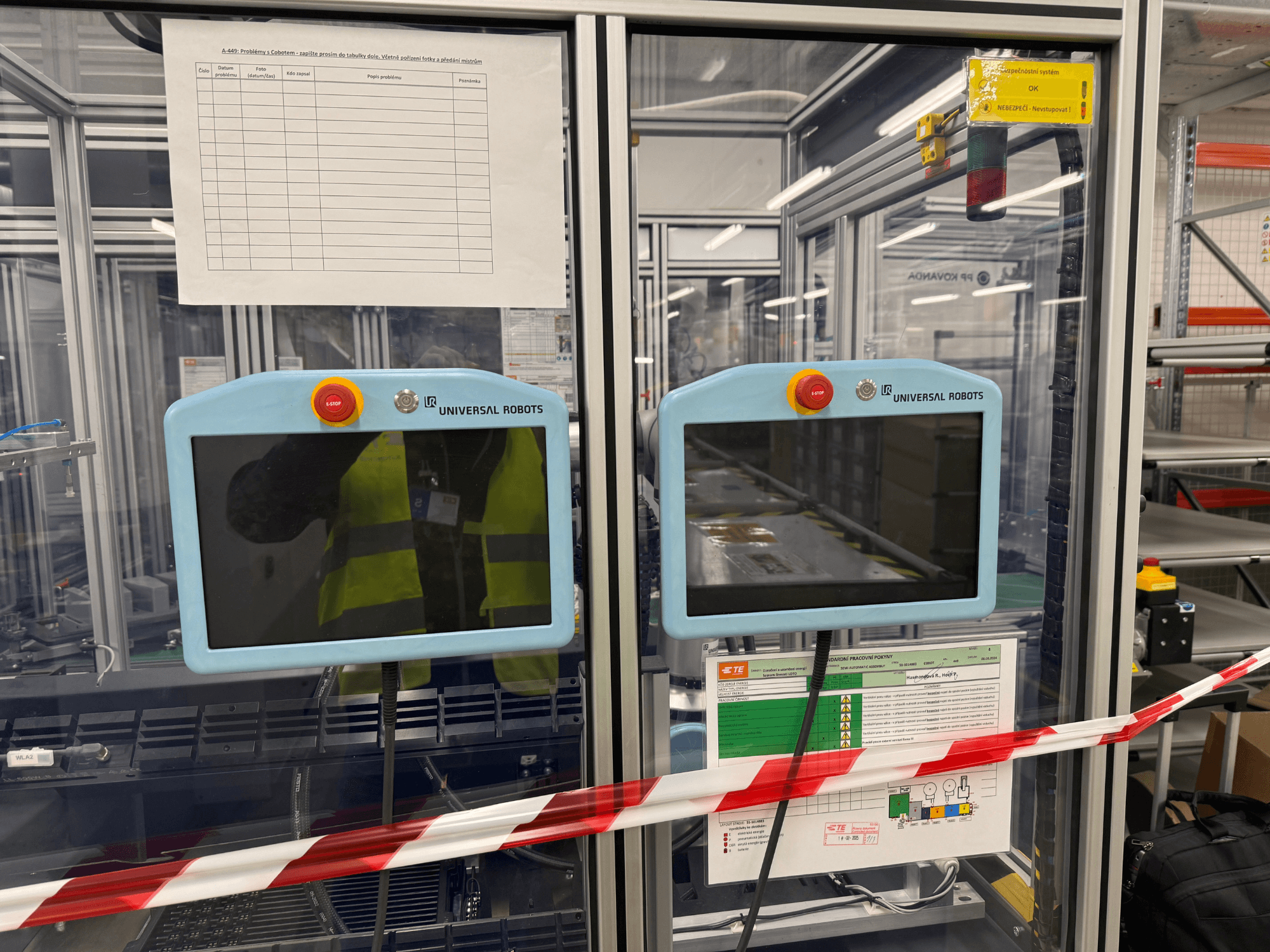 Universal Robots UR5 e -robottikäsivarren ohjauspaneeli, jossa on kaksi näyttöä, hätäpysäytyspainikkeet ja turvallisuusohjeet.