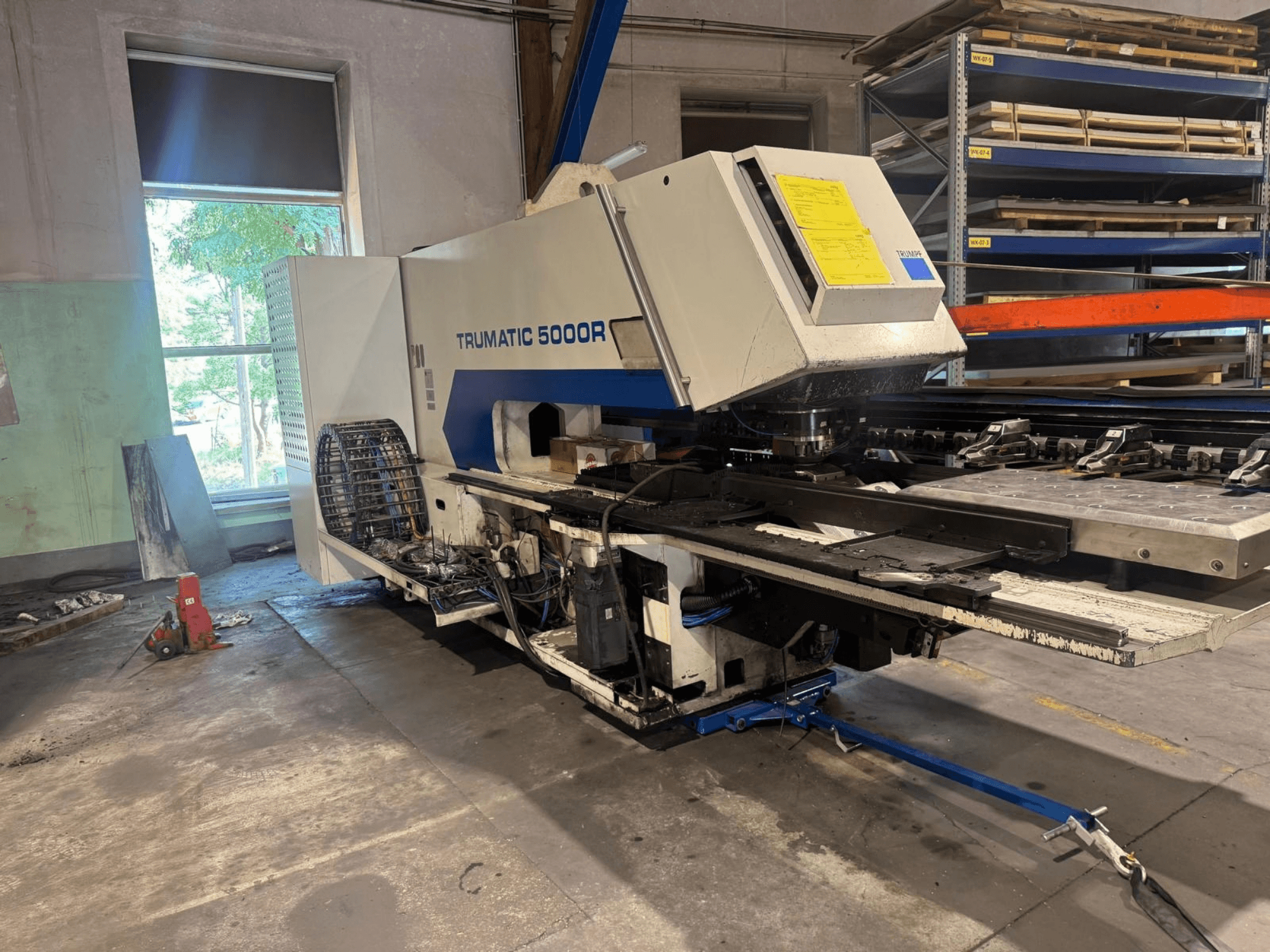 CNC-lävistyskone TRUMPF TRUMATIC 5000R työpajassa, etunäkymä, jossa näkyvät sen ohjauslaitteet ja lävistysalue.