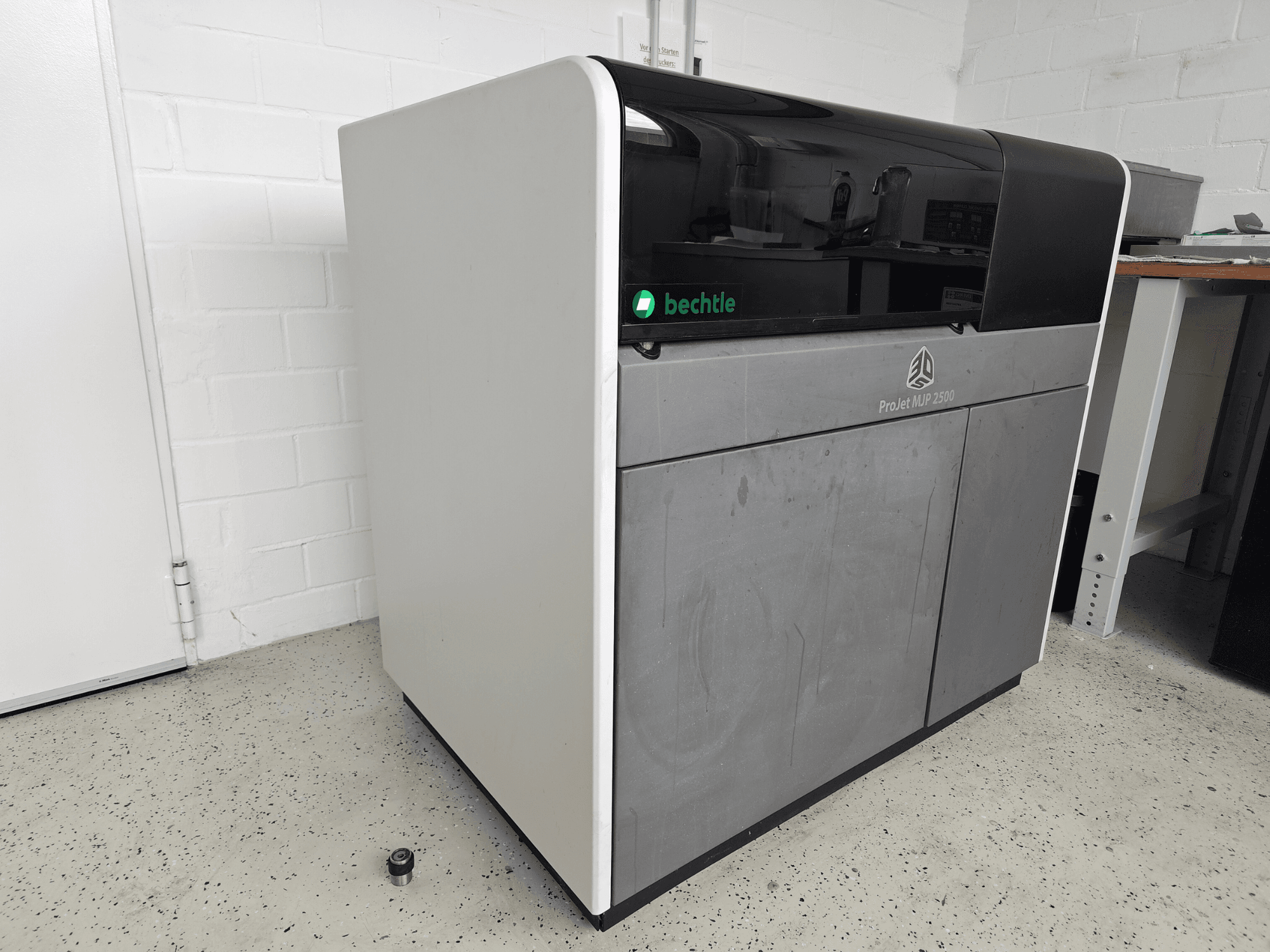 3D Systemsin ProJet MJP 2500 Plus -muovitulostin edestä katsottuna; laitteessa on tyylikäs muotoilu, jossa yläosa on tumma ja runko vaalea.